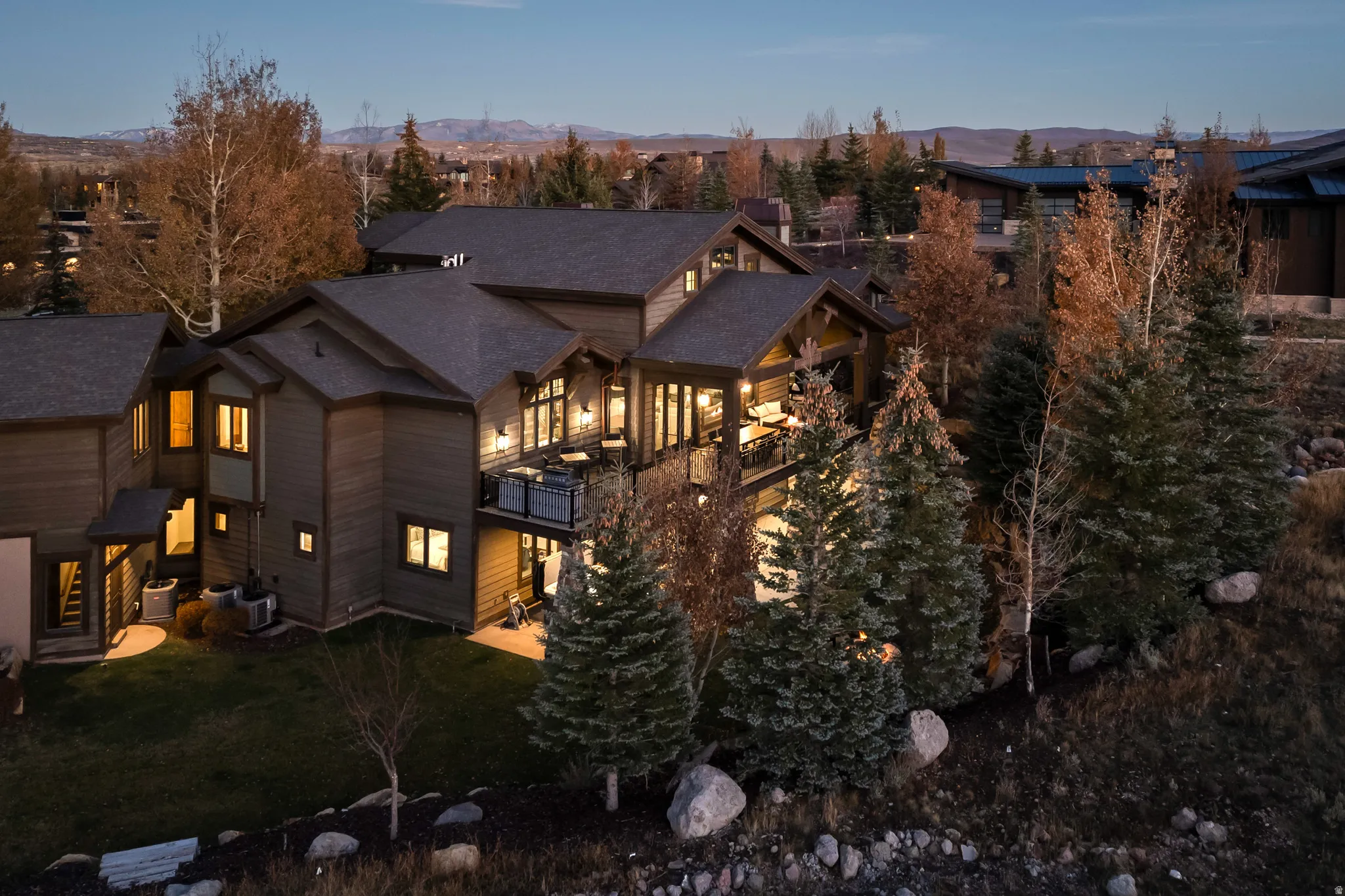 Back of house featuring a mountain view, a lawn, and a balcony