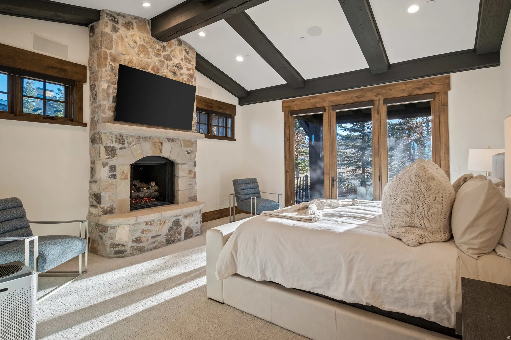 Carpeted bedroom featuring a stone fireplace, access to outside, vaulted ceiling, and recessed lighting