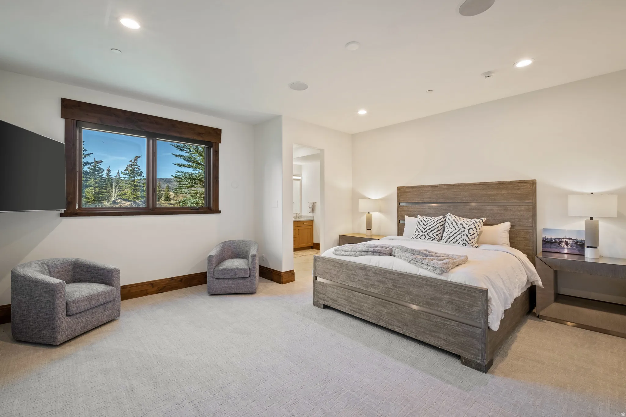 Bedroom with light carpet, ensuite bathroom, and recessed lighting