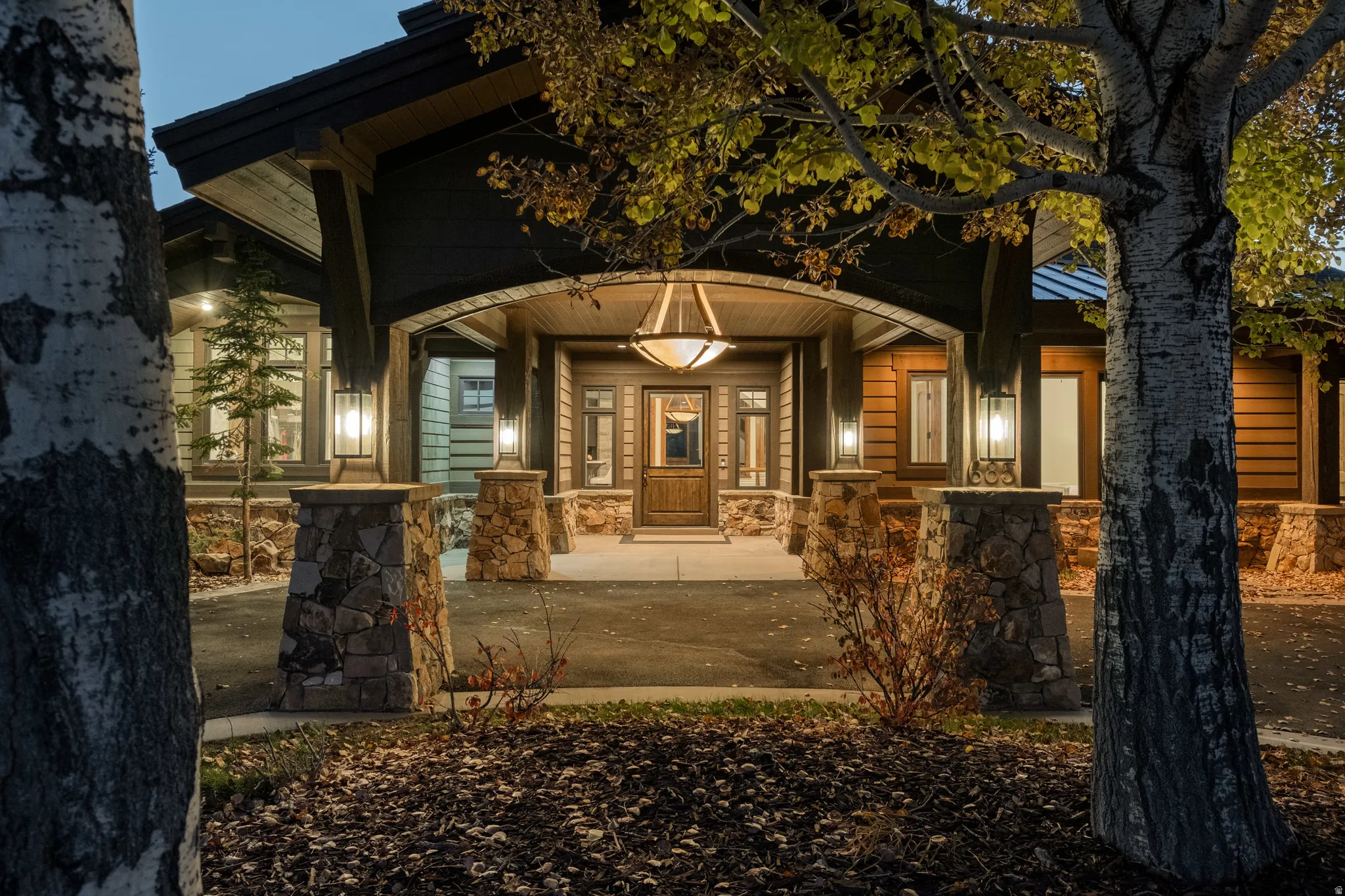 Entrance to property with covered porch and stone siding