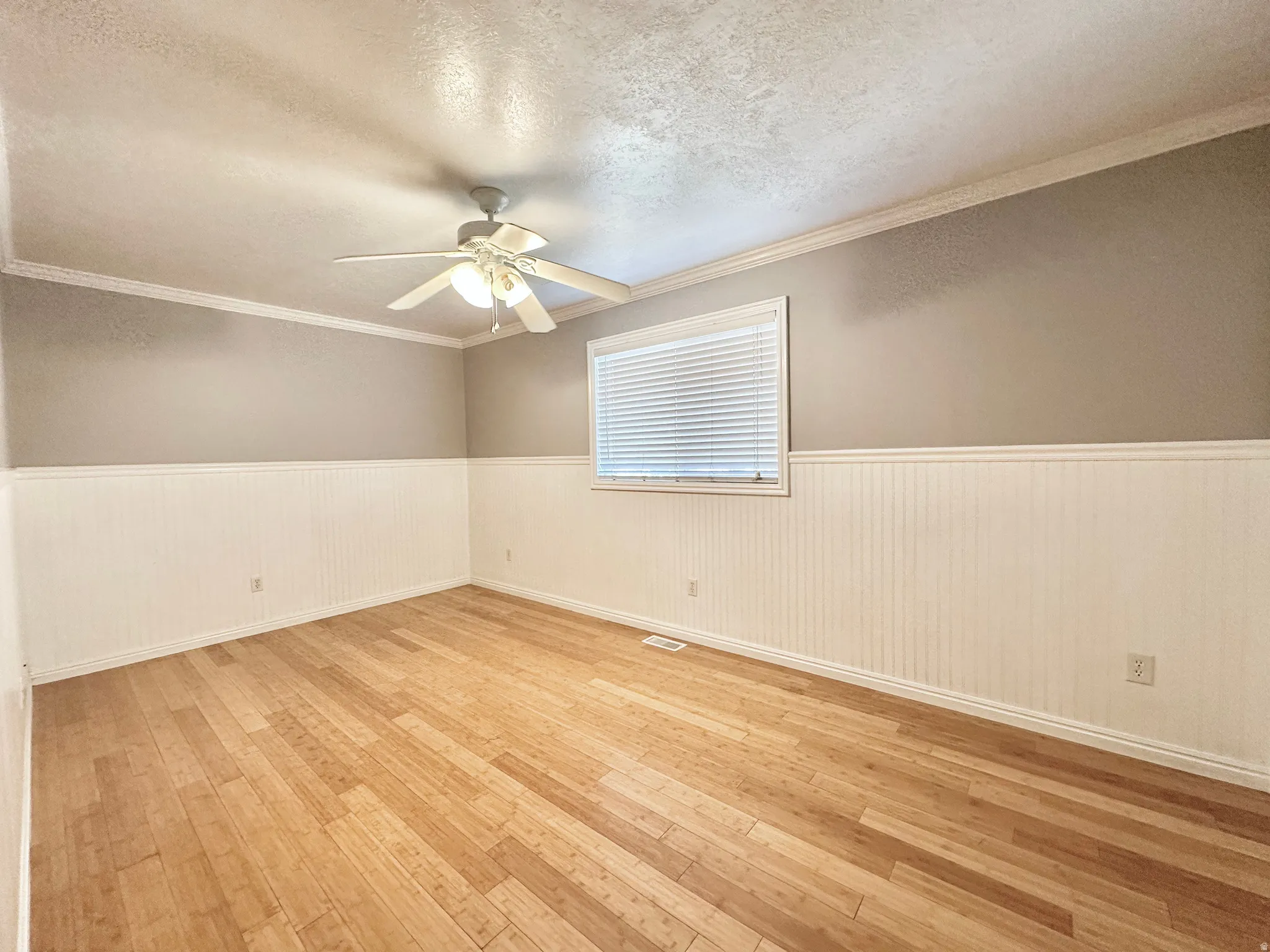 Bedroom 2 upstairs with ceiling fan, bamboo flooring, and window with view to east mountain