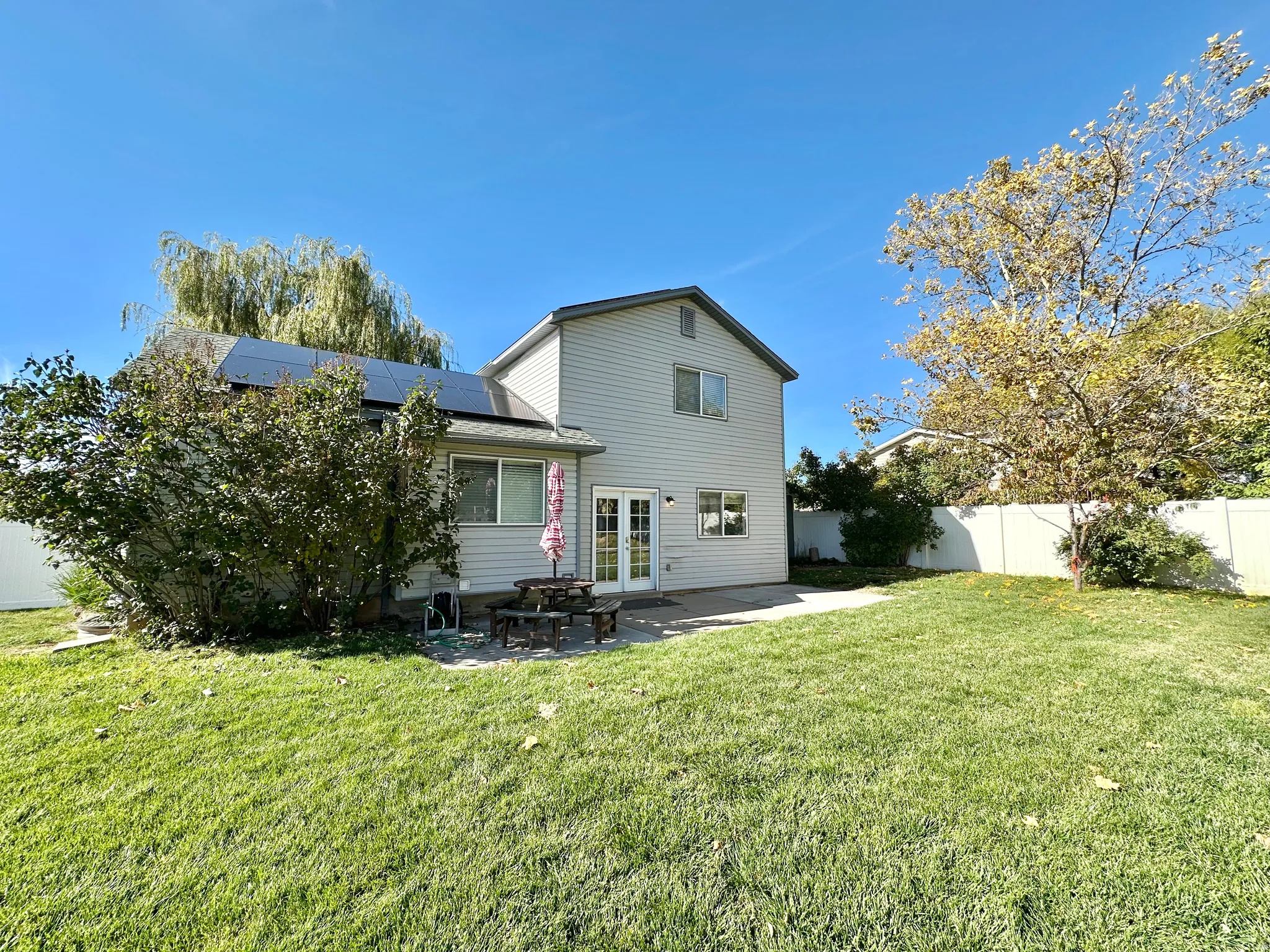 Rear view toward house, solar panels, picnic table, concrete landing