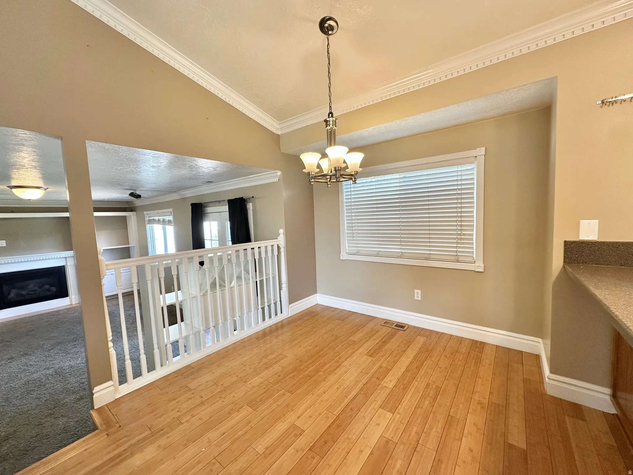 Dining area with chandelier, bamboo flooring, window with view to east mountain and back yard.