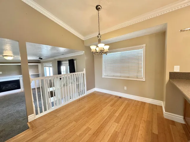 Dining area with chandelier, bamboo flooring, window with view to east mountain and back yard.