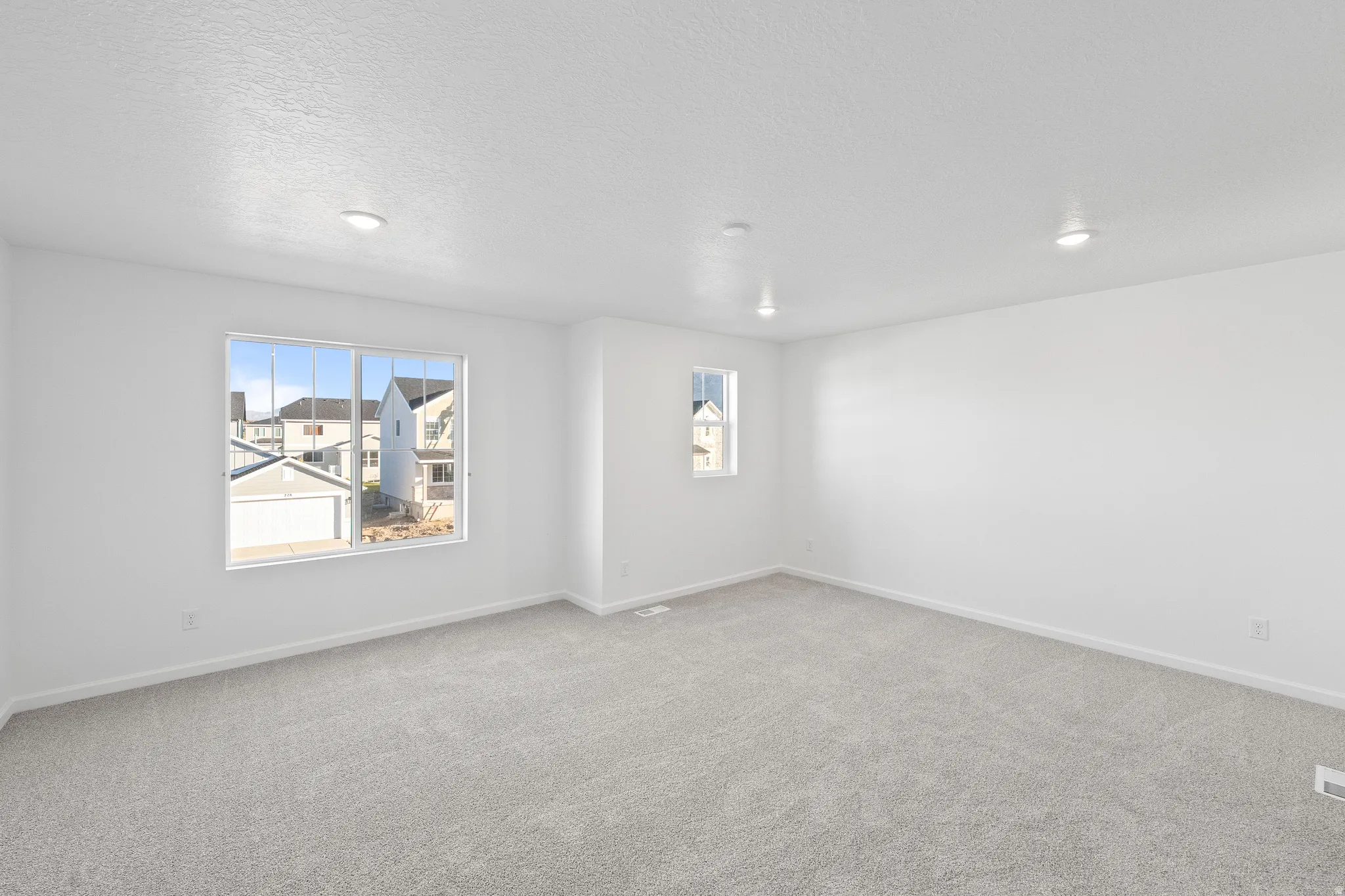 Unfurnished room with light colored carpet and a textured ceiling