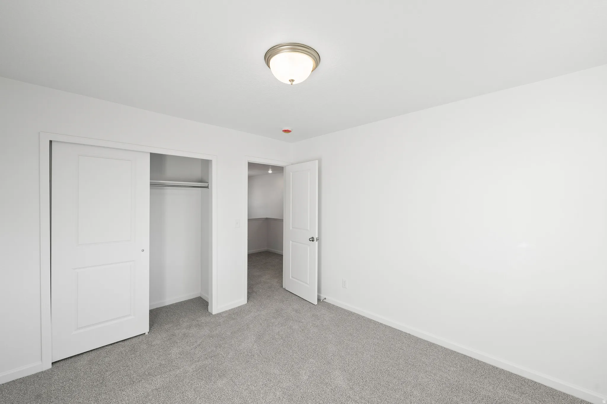 Unfurnished bedroom featuring light colored carpet and a closet