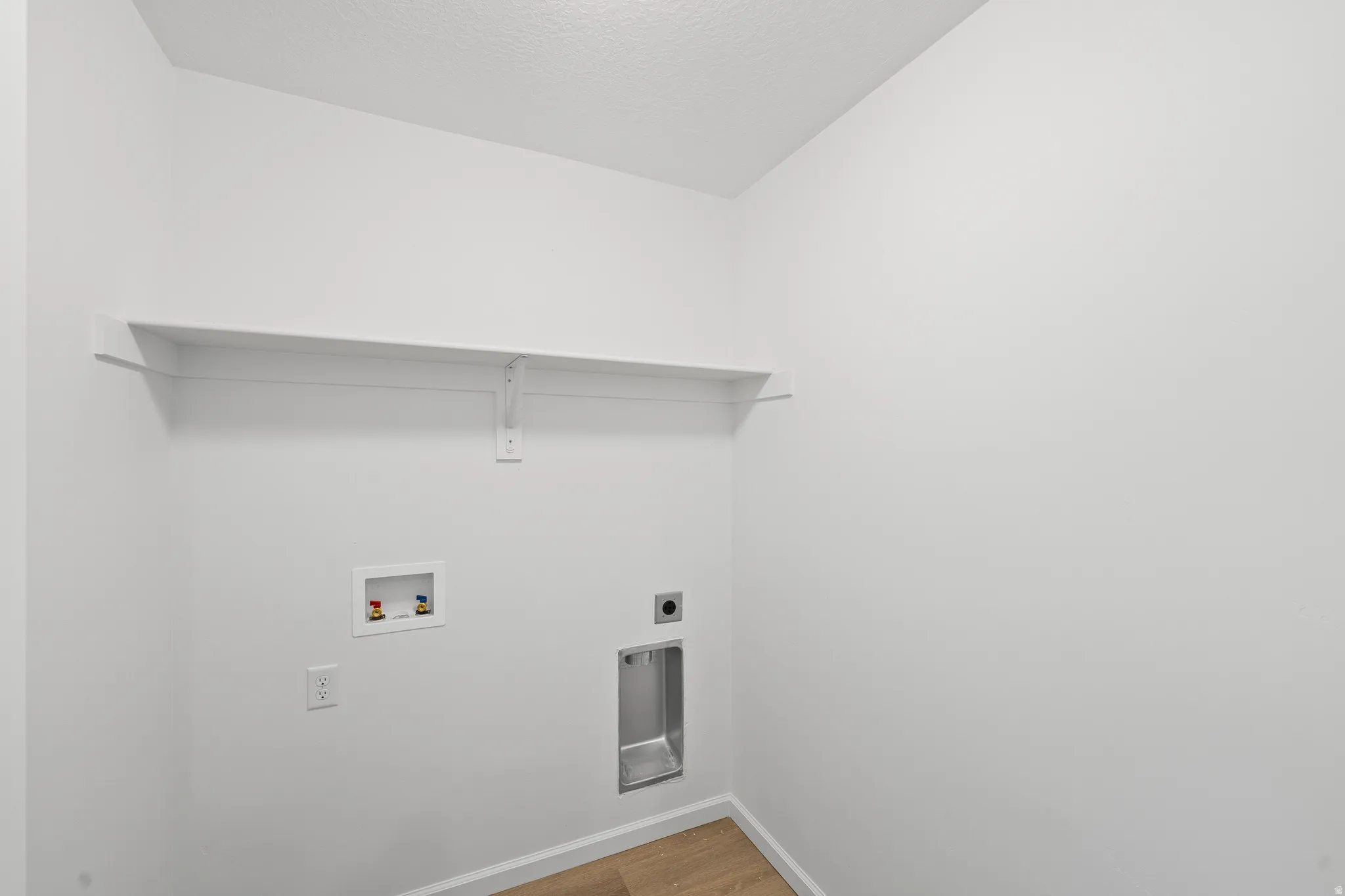 Laundry room featuring light wood-style floors, hookup for a washing machine, and hookup for an electric dryer