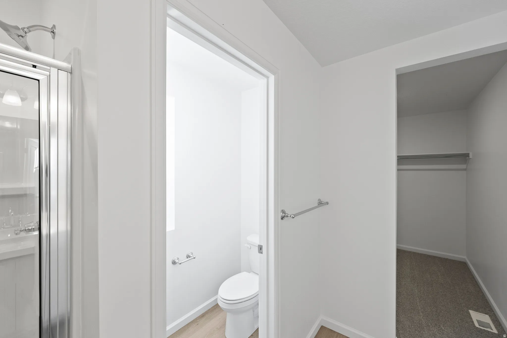 Full bath featuring a shower stall and a walk in closet