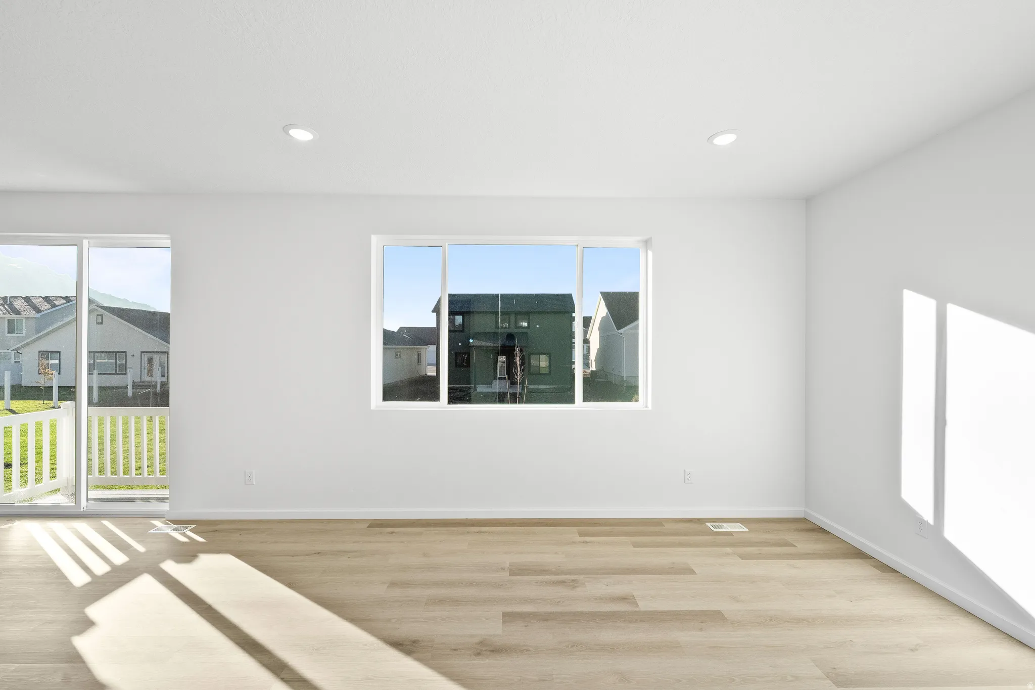 Spare room featuring healthy amount of natural light, light wood finished floors, and recessed lighting