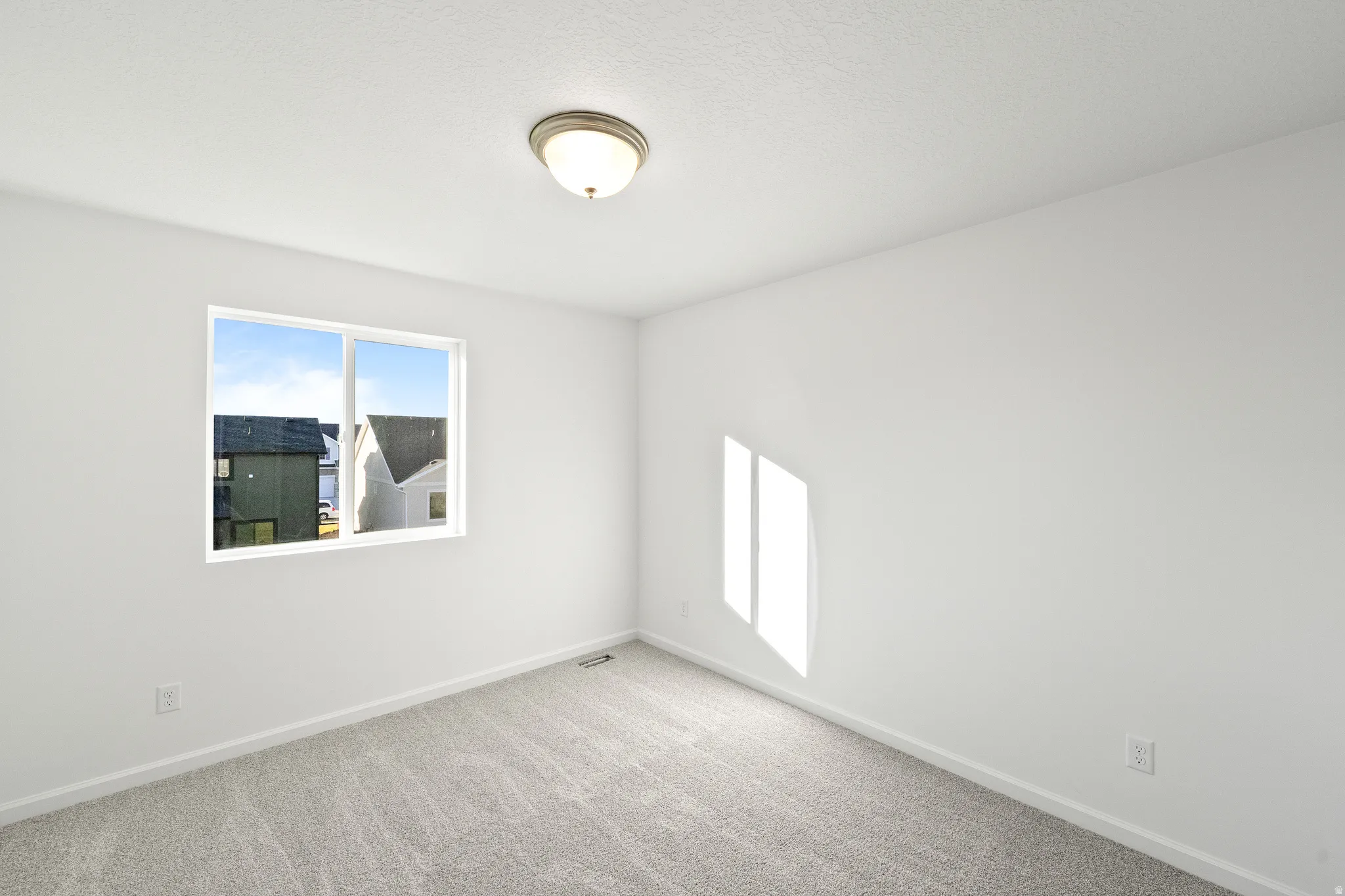 Carpeted spare room with baseboards