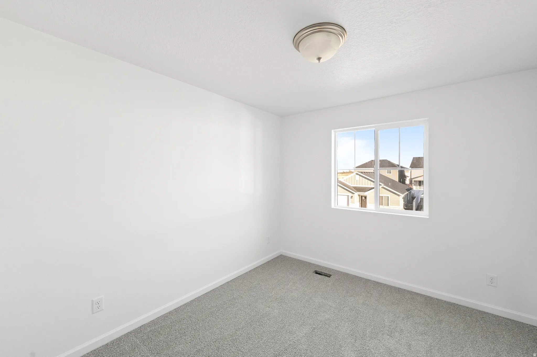 Empty room featuring carpet and baseboards