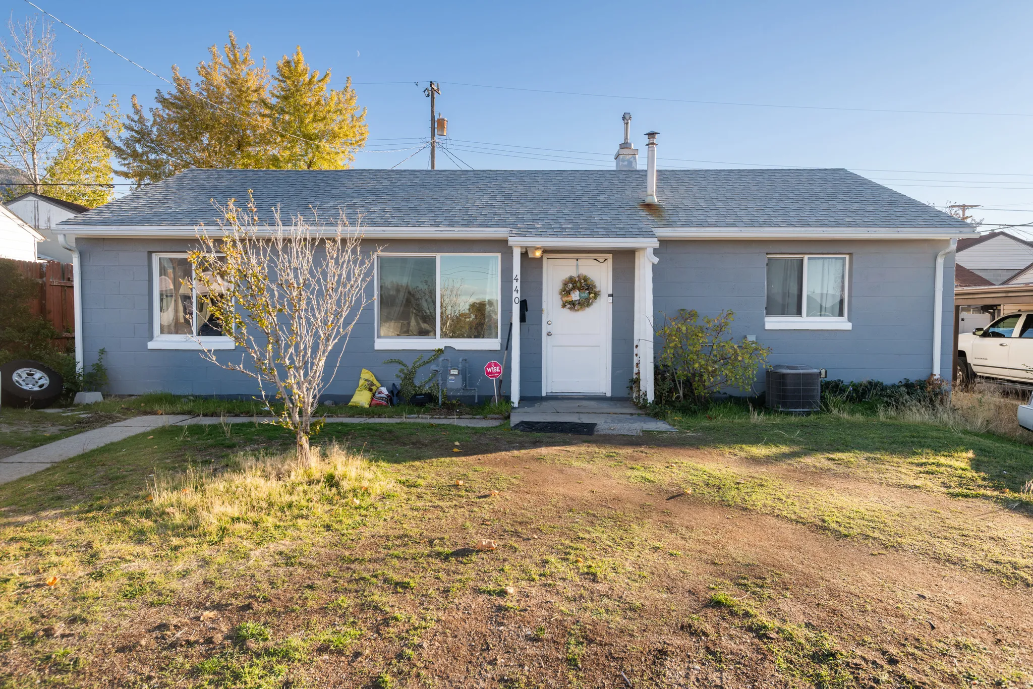 View of front facade with roof with shingles, concrete block siding, and a front yard
