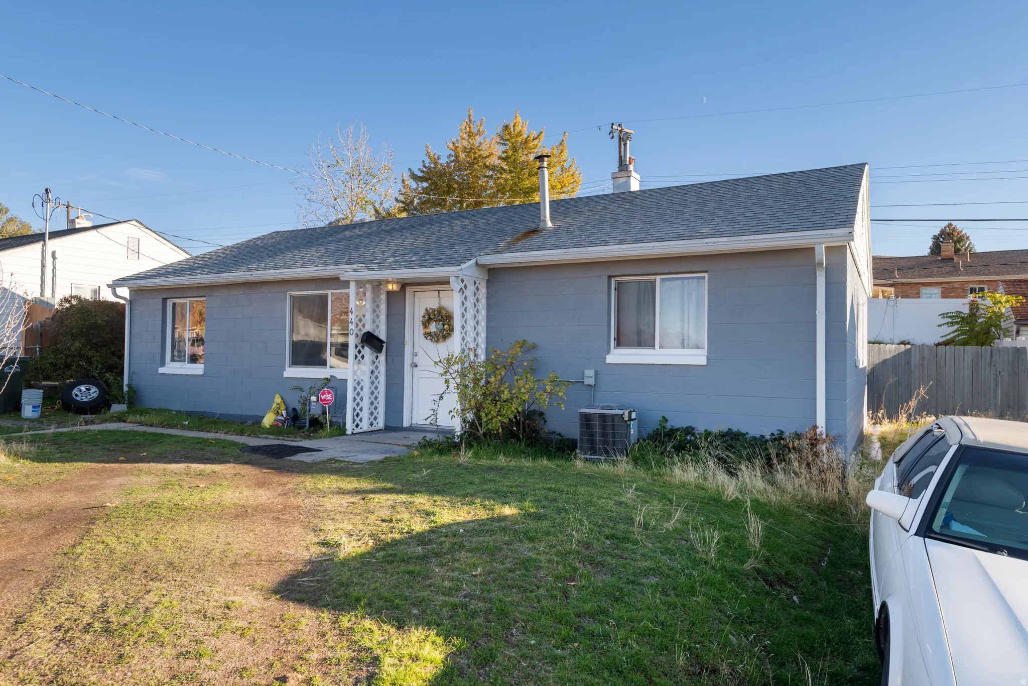 View of front of home with a shingled roof, concrete block siding, and a chimney