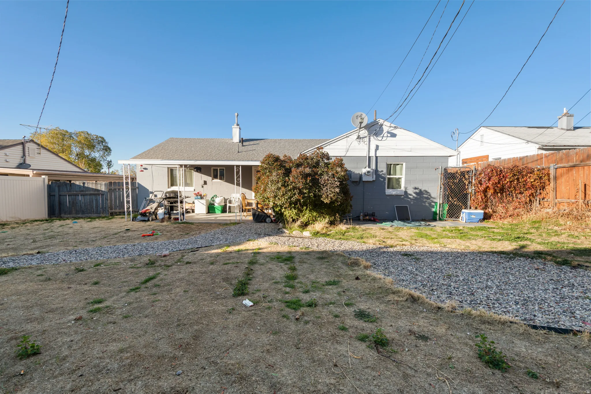 Rear view of property featuring a fenced backyard, a chimney, and a patio