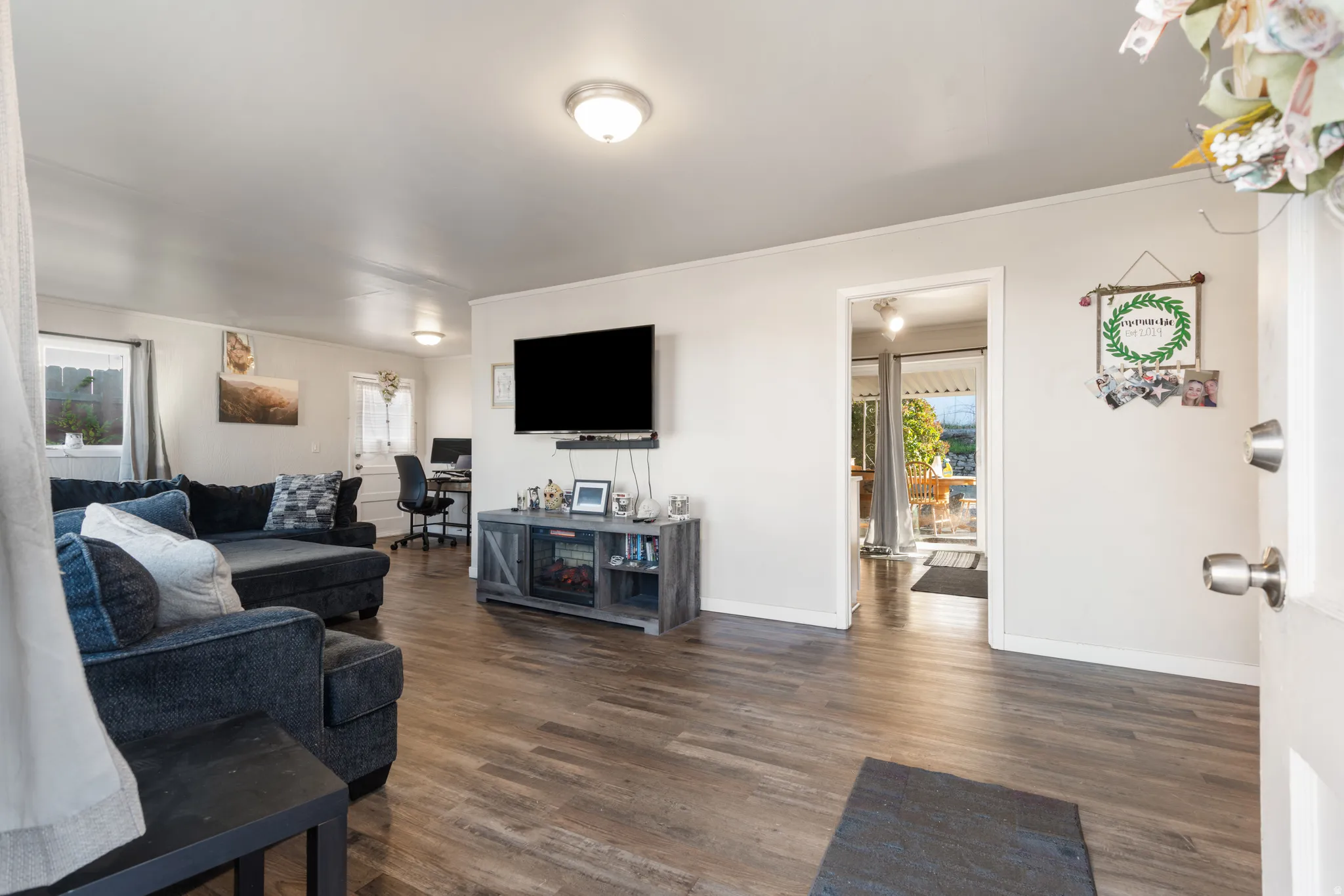 Living area featuring a desk, dark wood finished floors, and ornamental molding