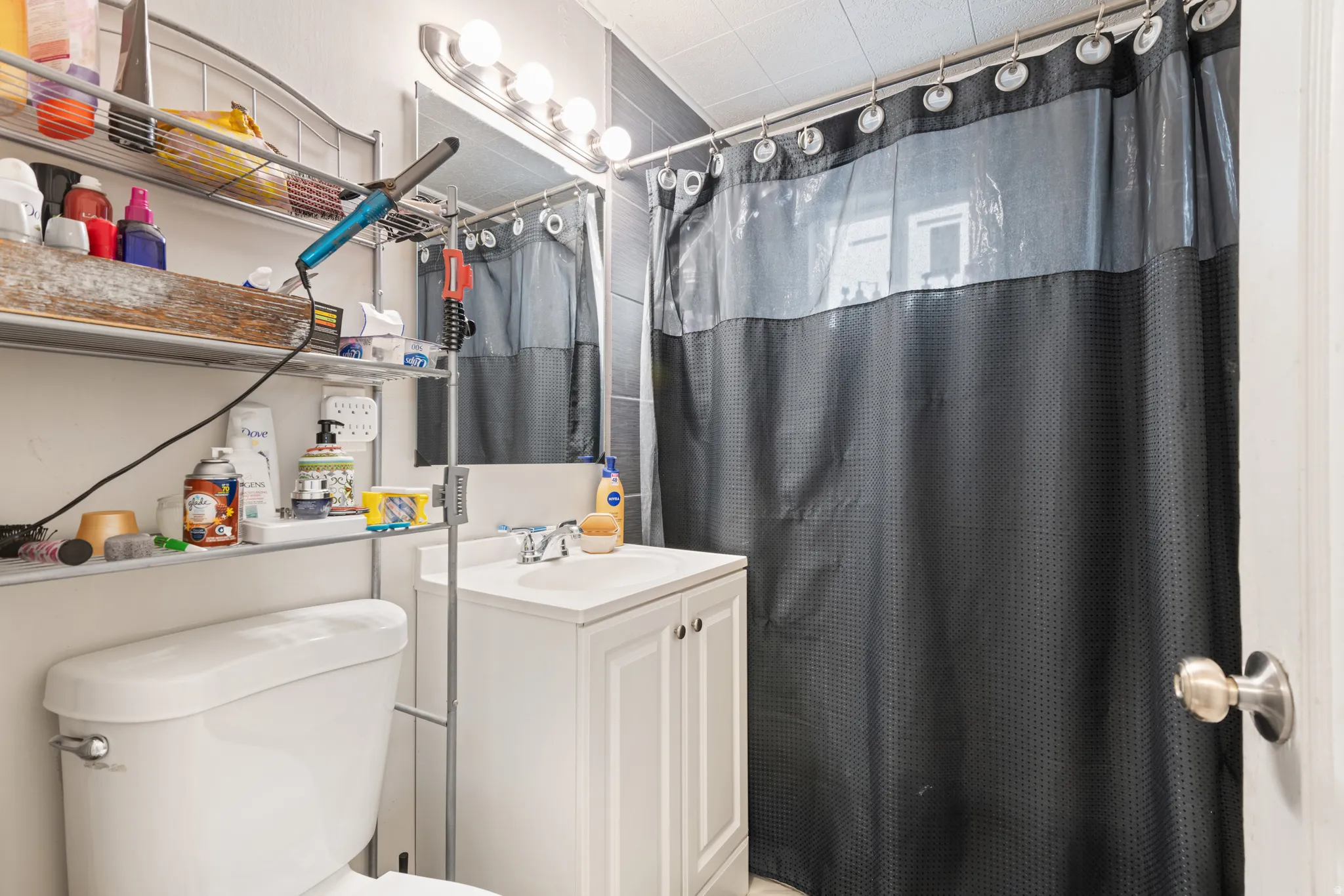 Full bathroom featuring curtained shower and vanity