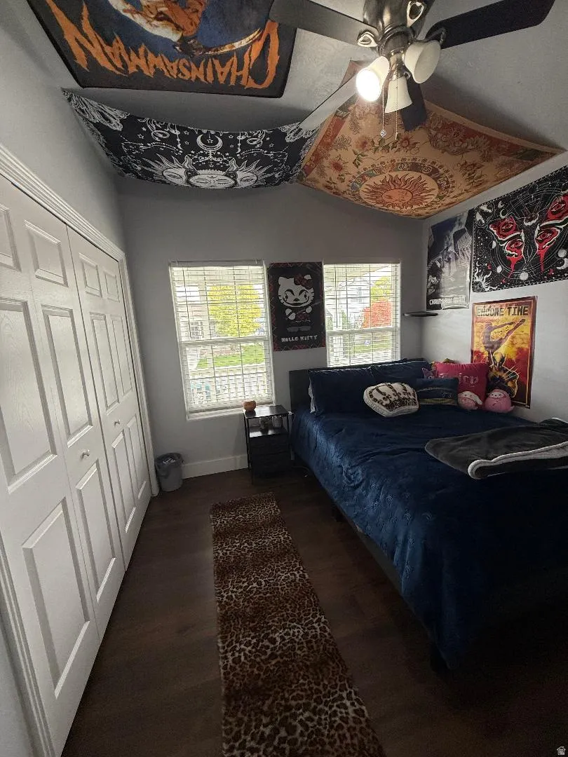 Bedroom featuring dark wood-style floors, a closet, and a ceiling fan