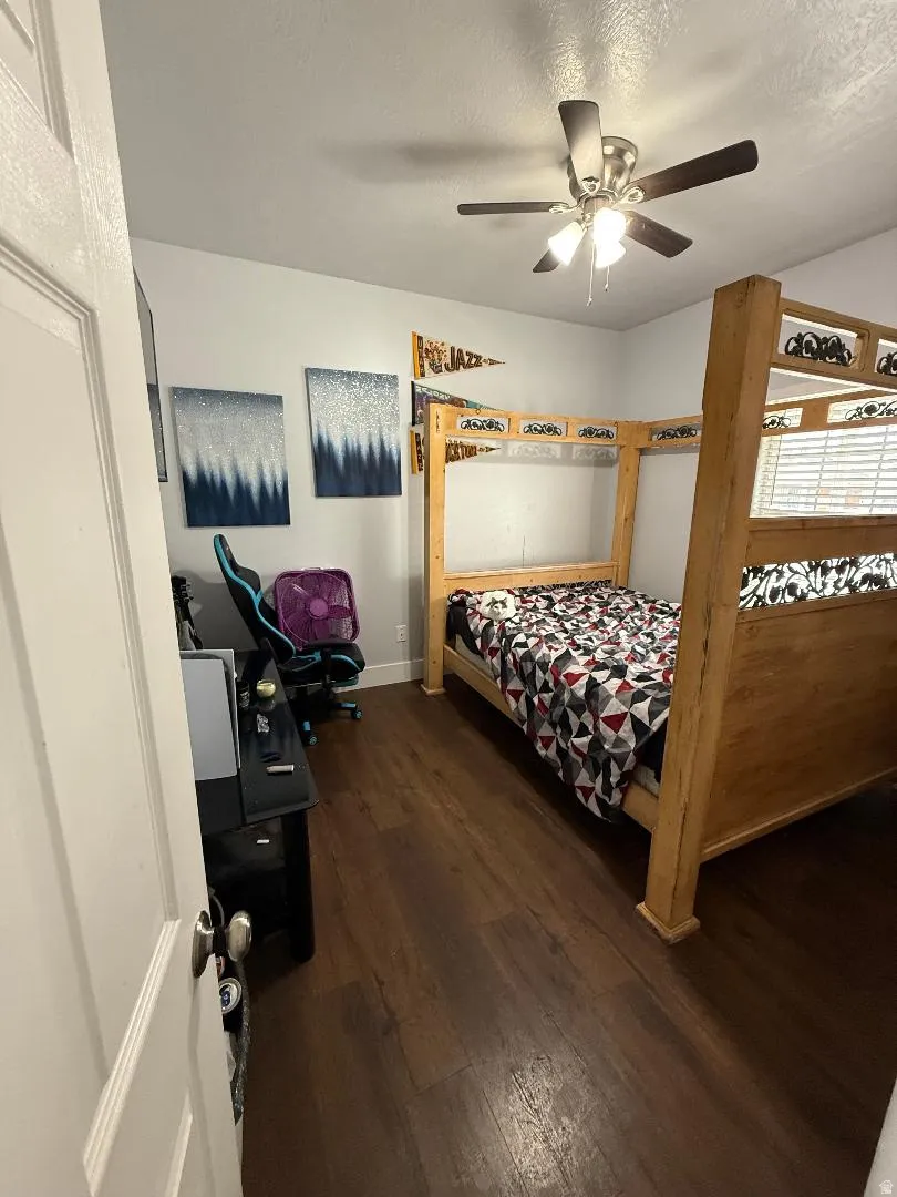 Bedroom featuring dark wood-type flooring, ceiling fan, and a textured ceiling