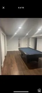 Recreation room with billiards table and dark wood-style flooring