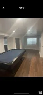 Playroom with billiards and dark wood-style floors