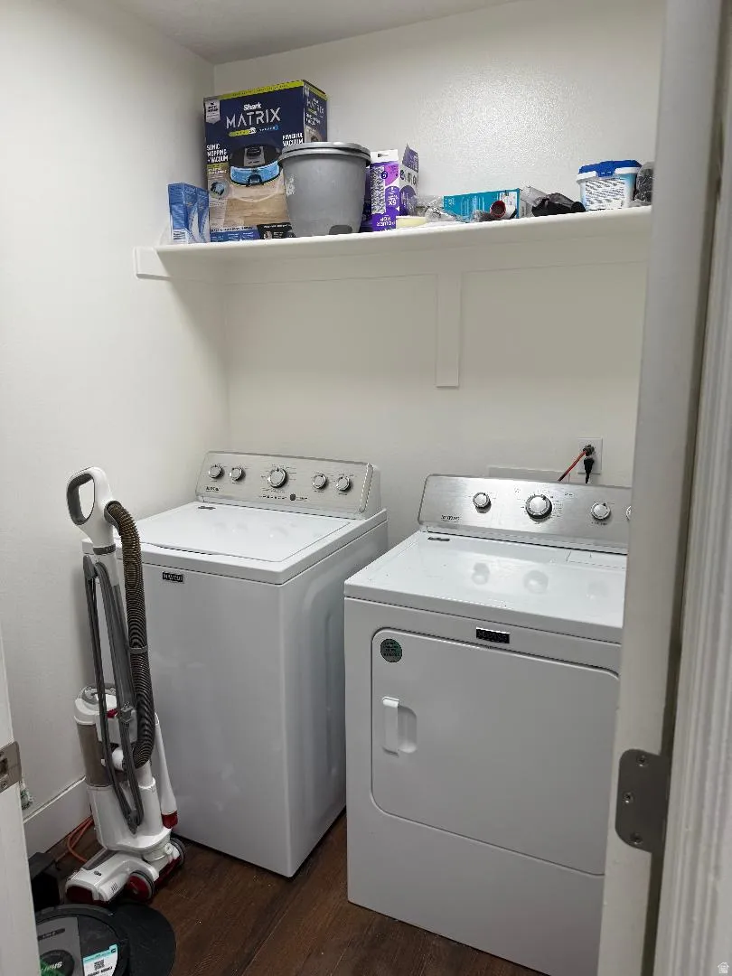 Laundry area featuring dark wood-type flooring and independent washer and dryer