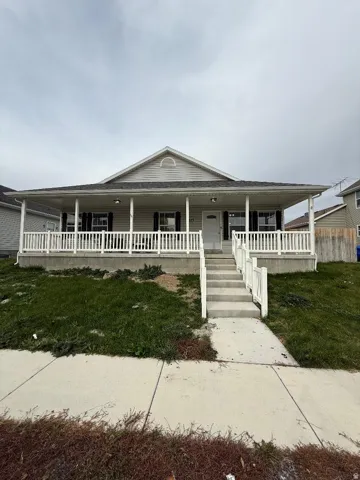 View of front of property featuring a porch and a front yard