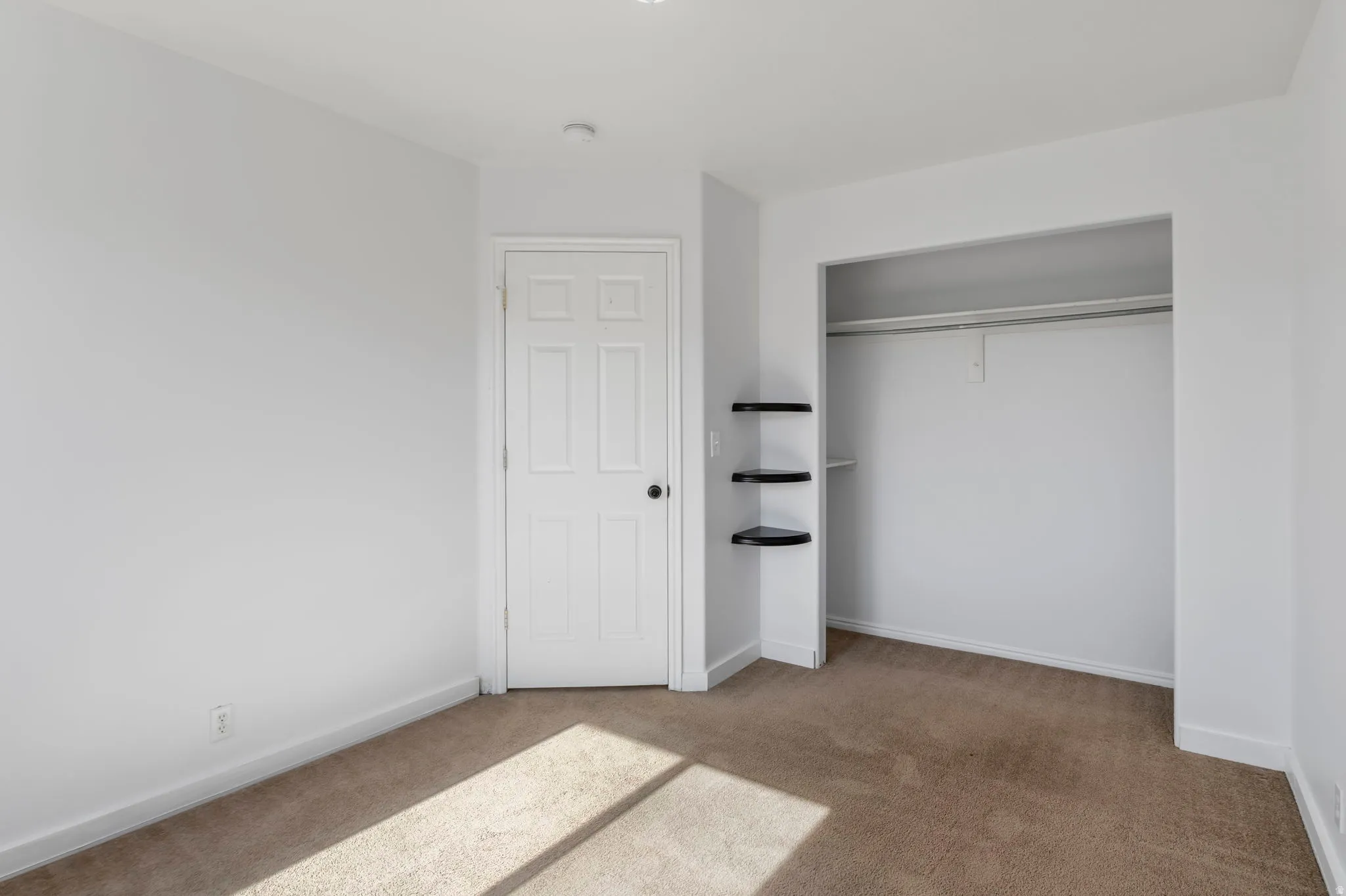 Unfurnished bedroom featuring light colored carpet and a closet