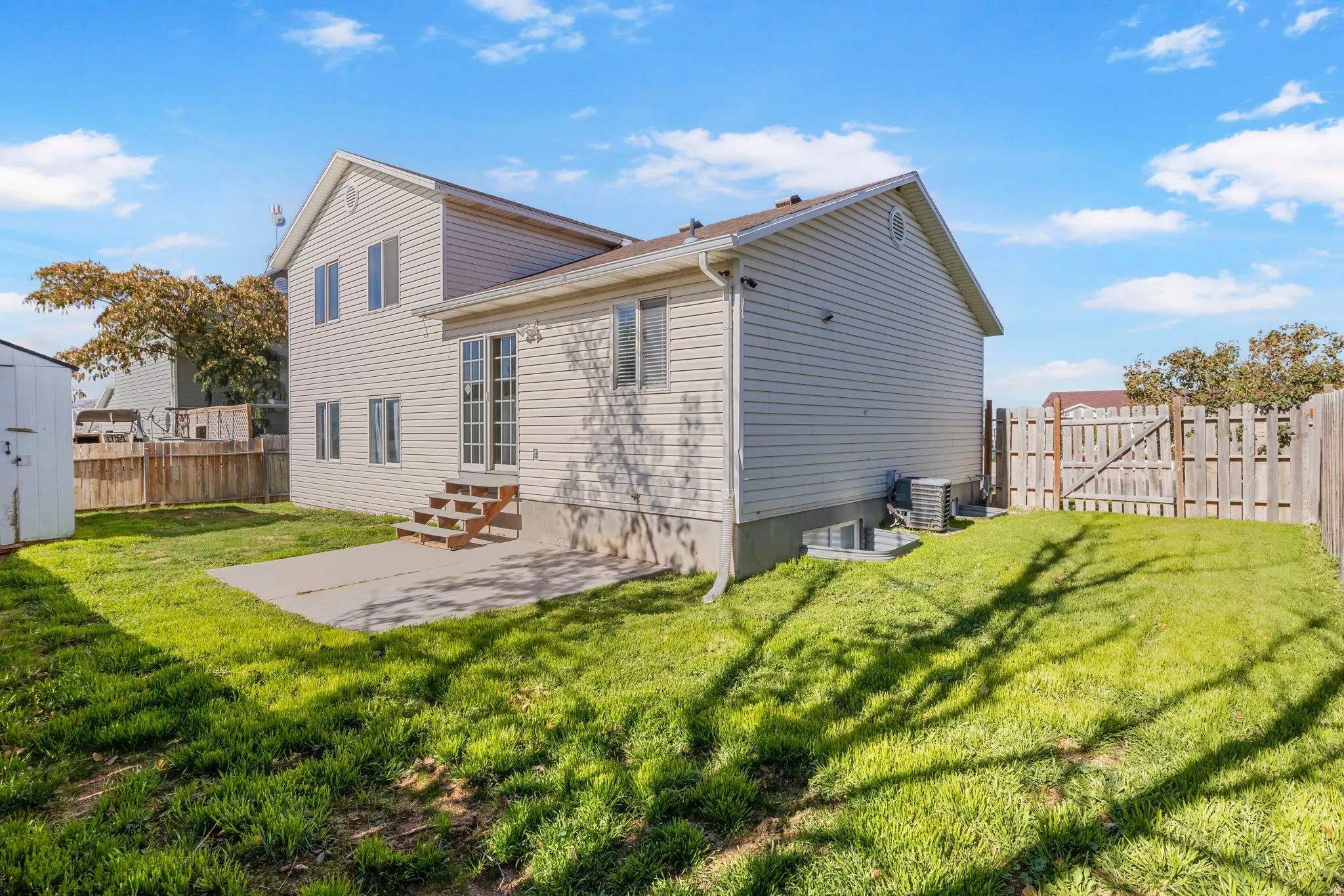 Back of house with a patio, a fenced backyard, entry steps, and a gate