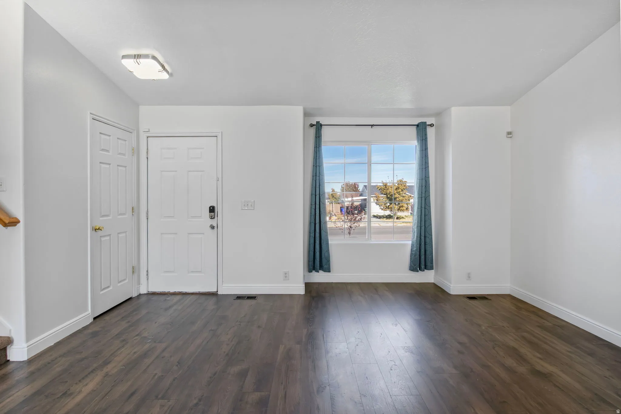 Entrance foyer with dark wood finished floors and baseboards