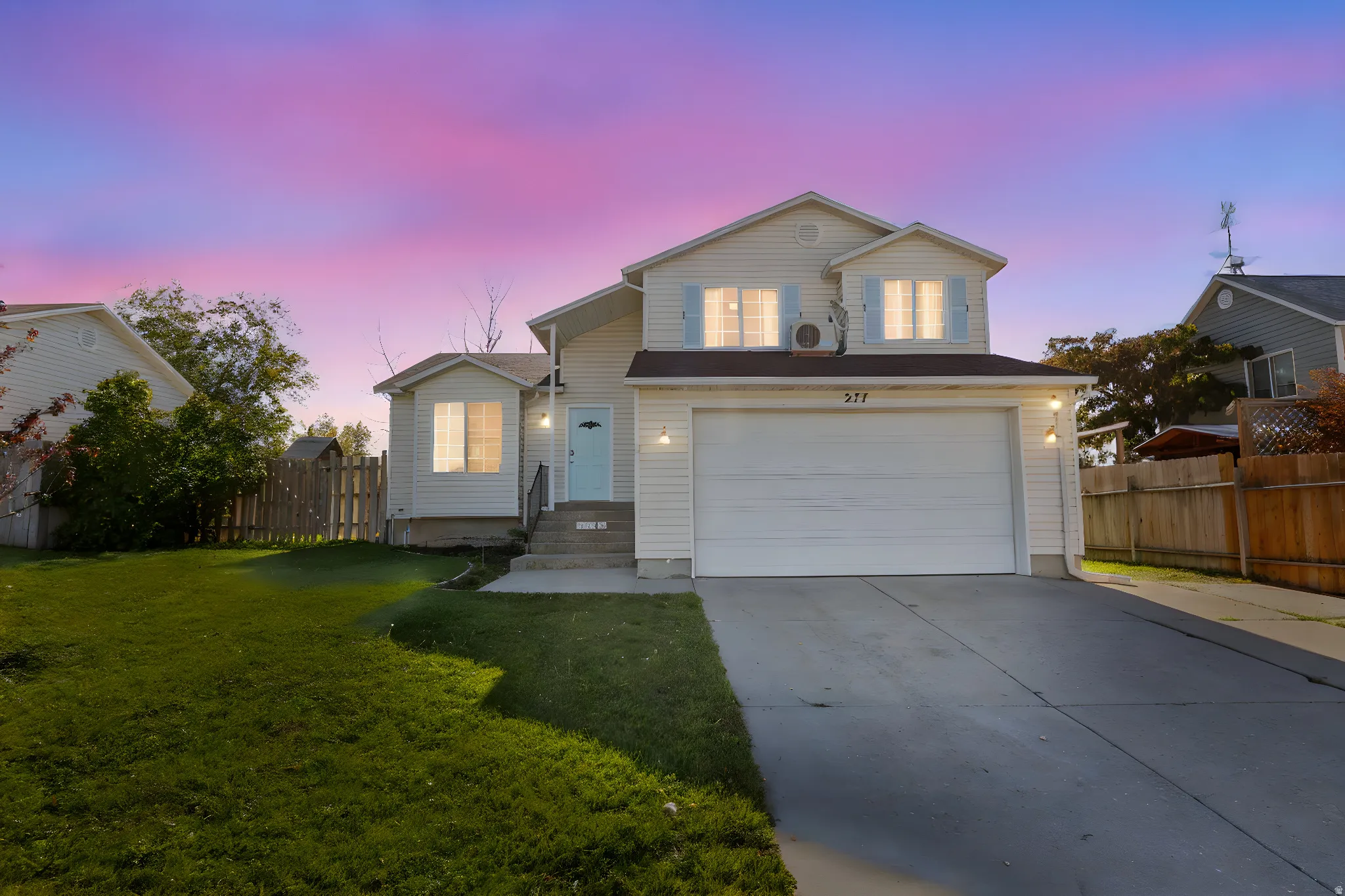 Traditional home featuring an attached garage and concrete driveway