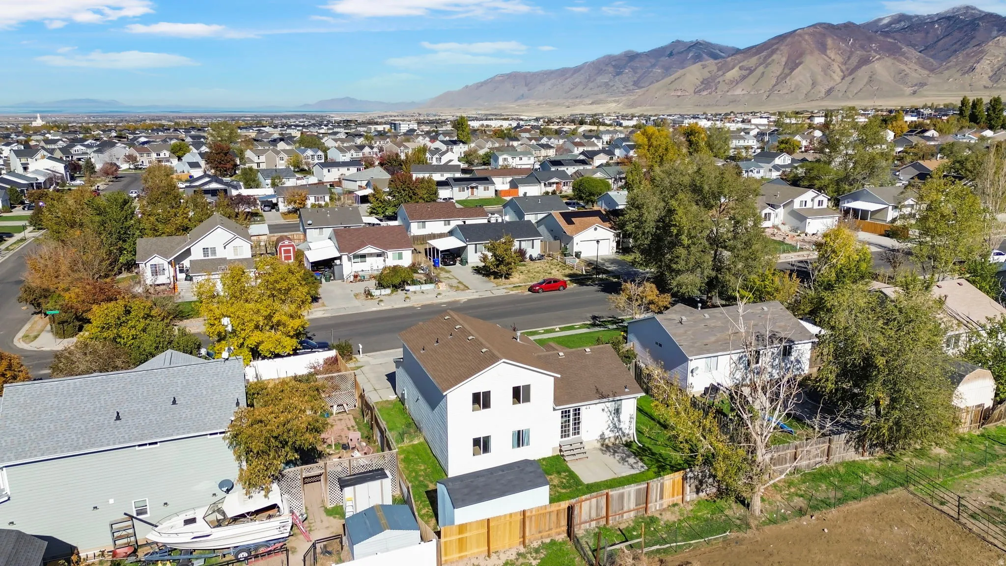 Aerial view of property and surrounding area with a mountain backdrop and nearby suburban area