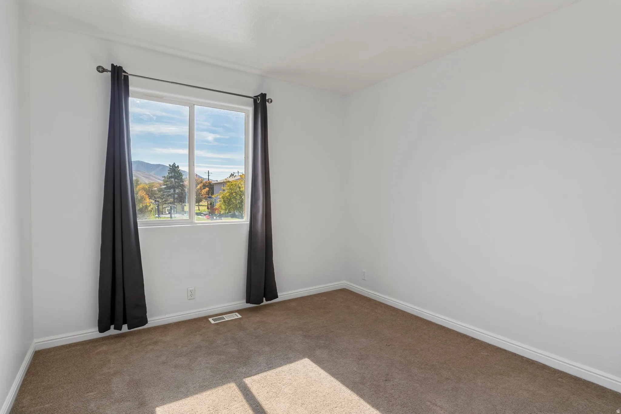 Carpeted spare room with baseboards and a mountain view