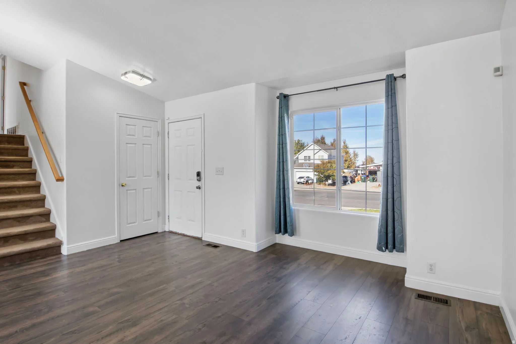 Unfurnished room featuring stairs and dark wood finished floors