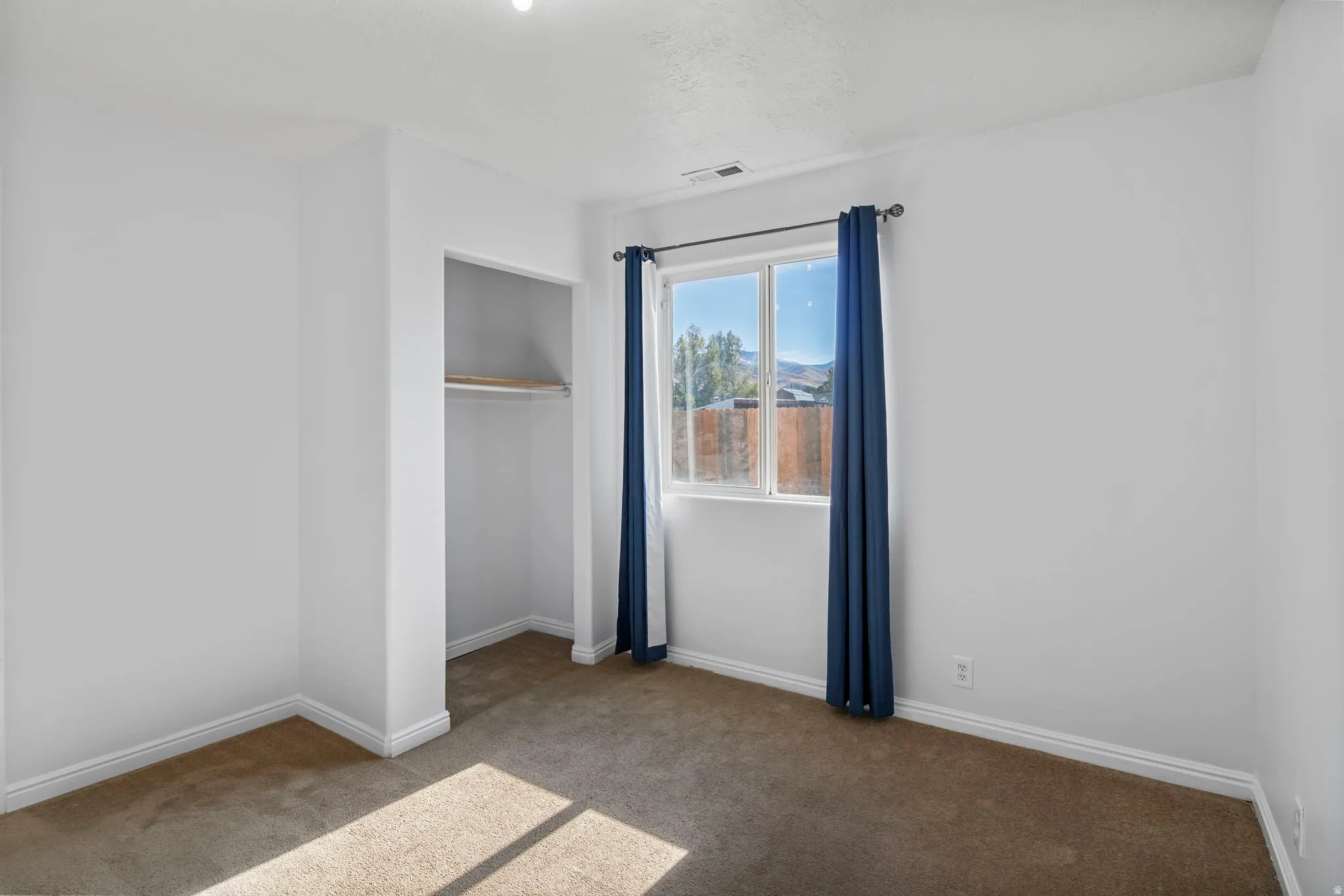 Unfurnished bedroom with carpet floors and baseboards