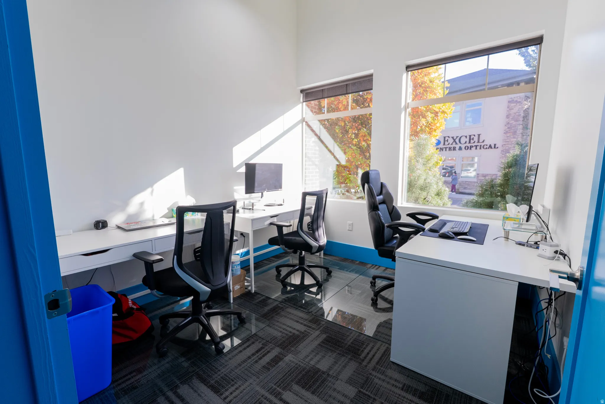 Office space featuring dark carpet and a high ceiling