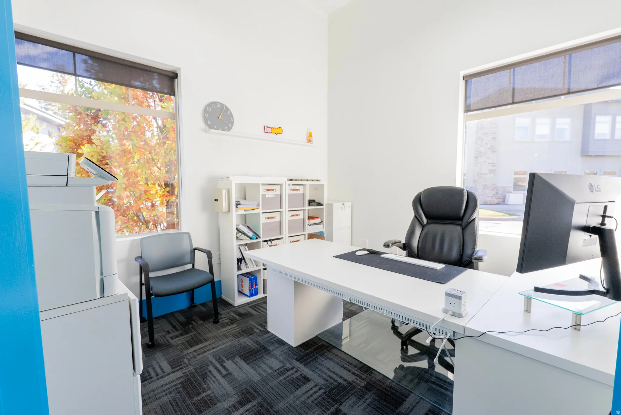 Office area featuring dark carpet and plenty of natural light