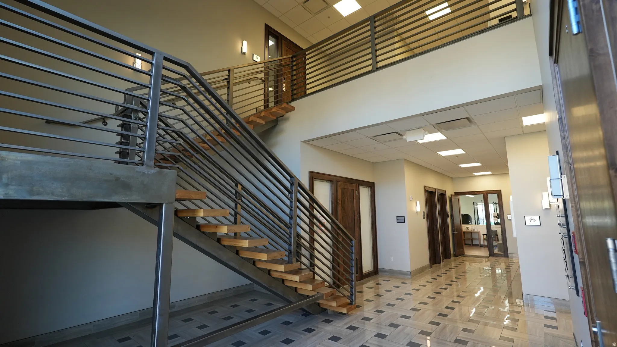 Stairs with a high ceiling and a paneled ceiling