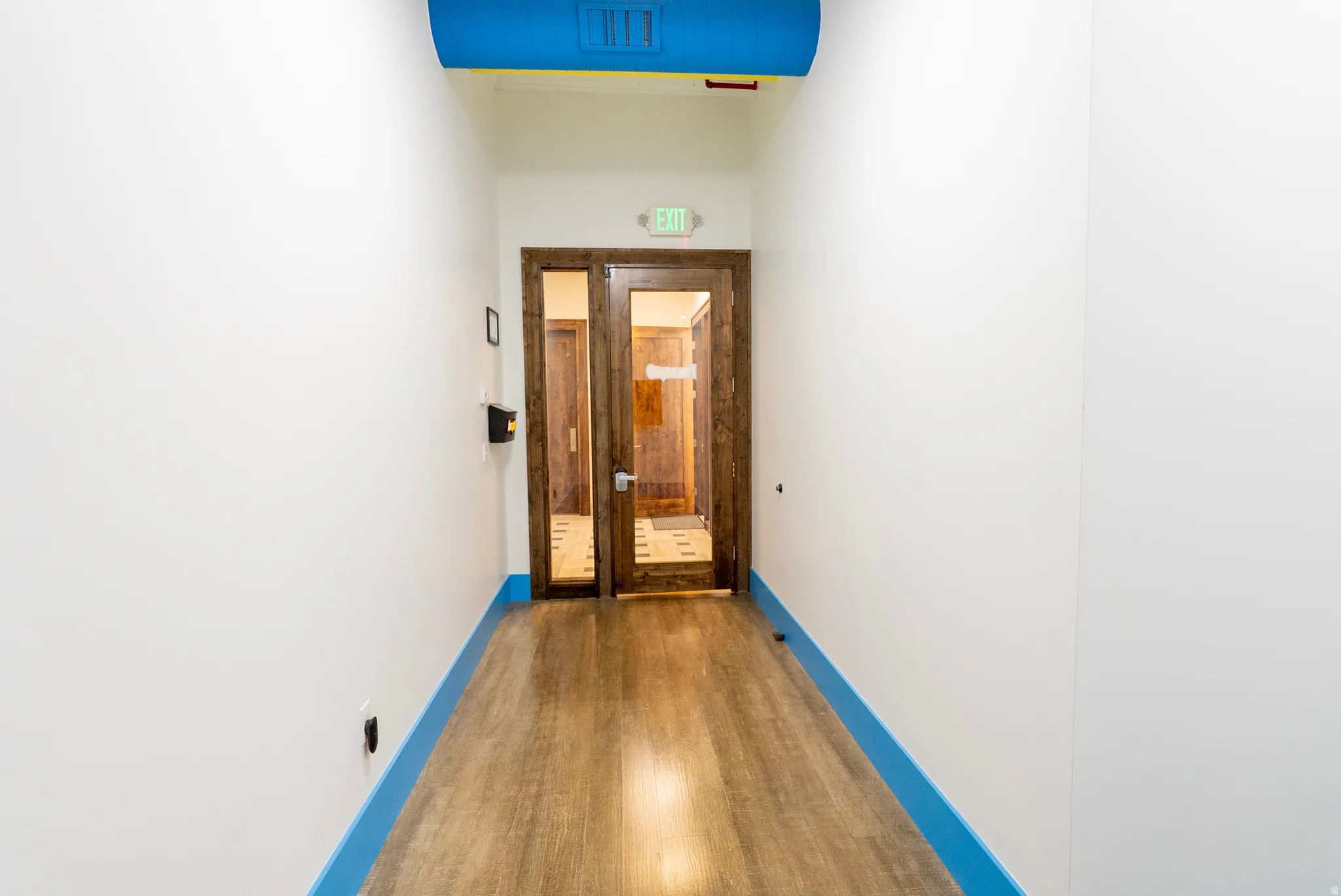 Corridor with wood finished floors and baseboards