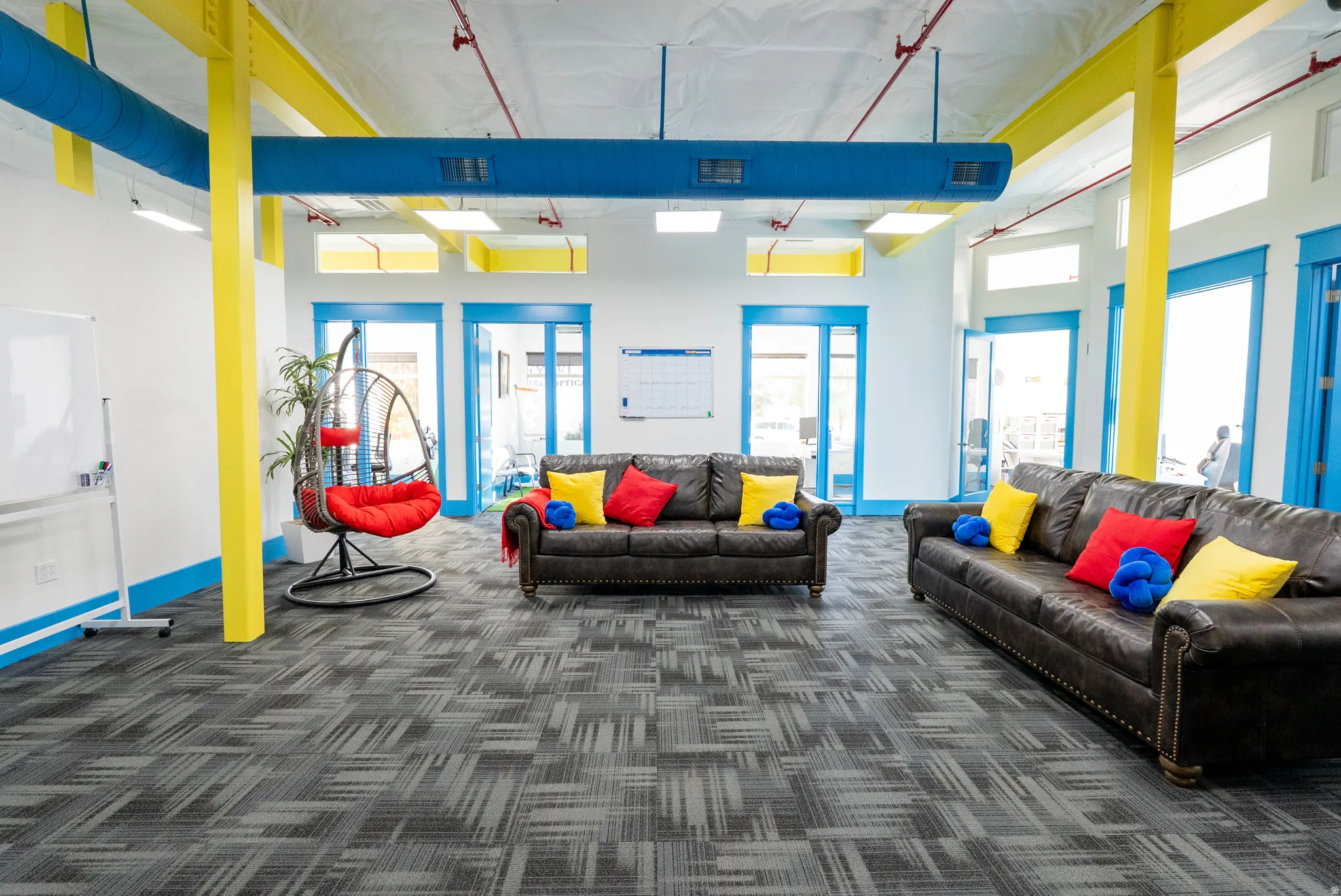 Lobby area with dark colored carpet, plenty of natural light, and a towering ceiling