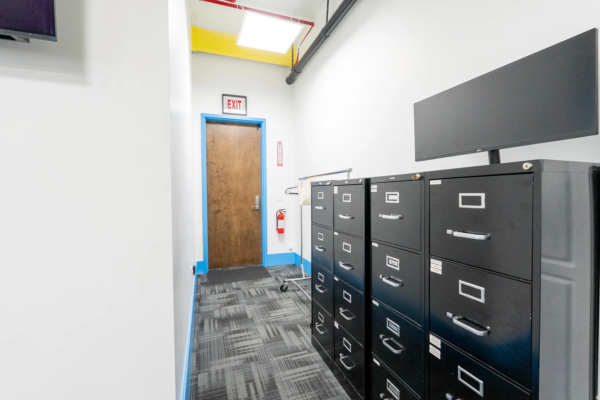 Hallway with dark colored carpet and baseboards