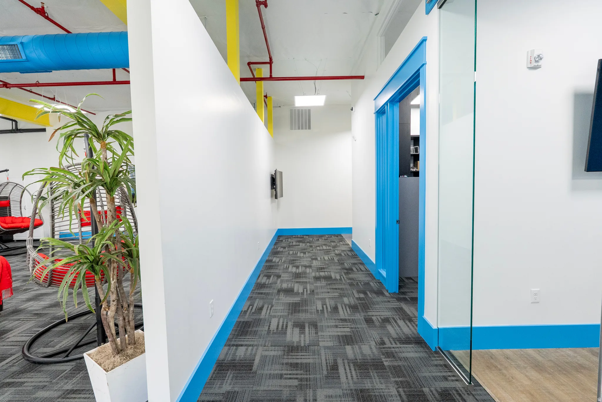 Hallway featuring dark colored carpet and baseboards