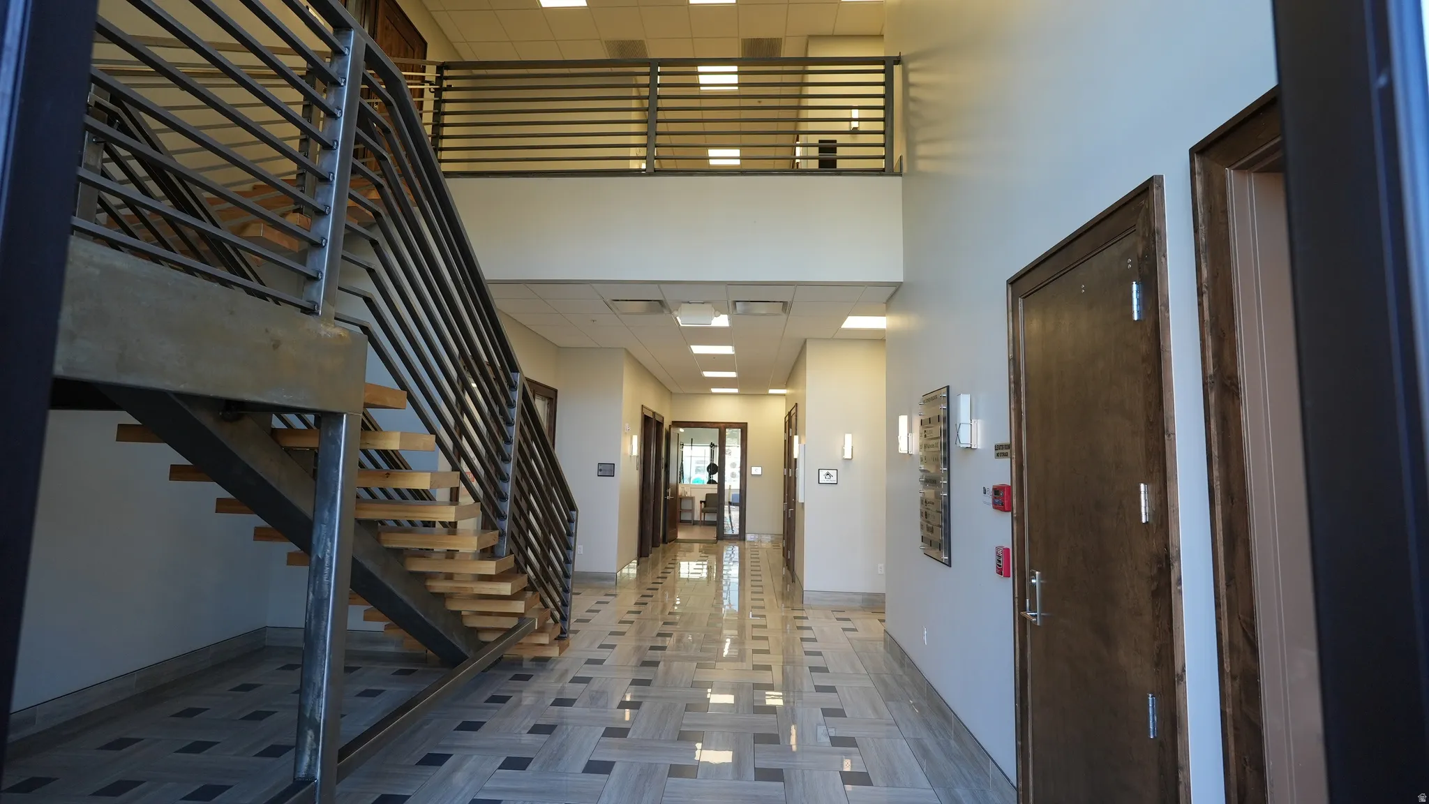 Foyer entrance featuring a high ceiling, a drop ceiling, and stairs