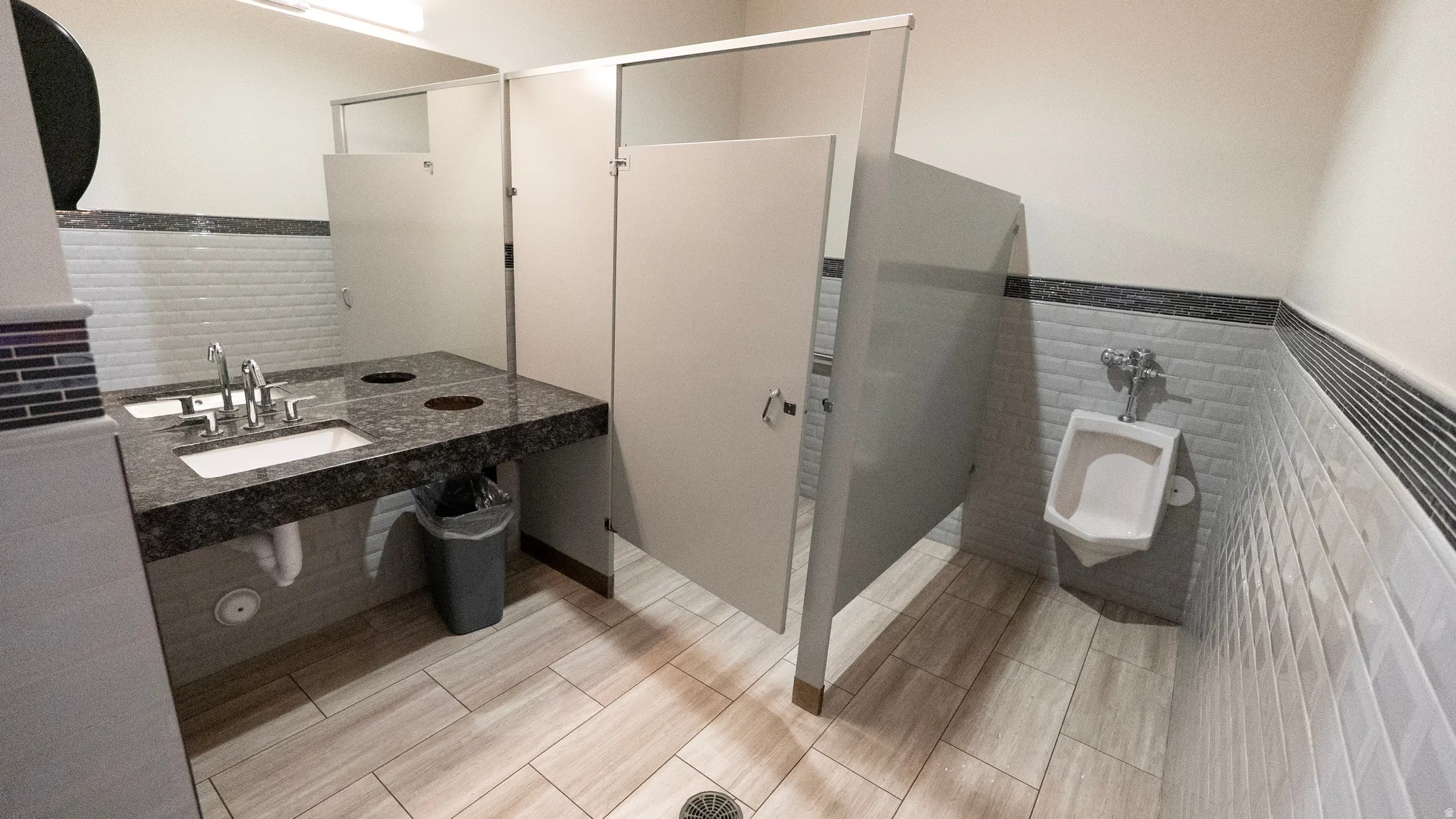 Full bathroom with tile walls, a wainscoted wall, vanity, and a shower stall