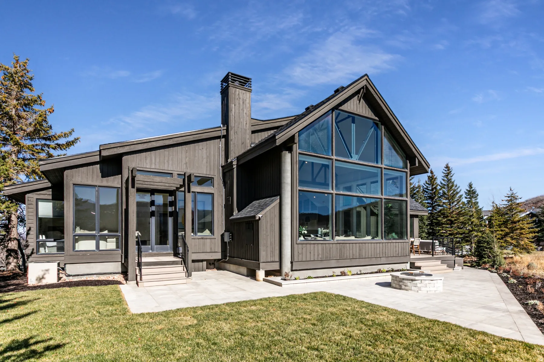 Back of house featuring a sunroom, a patio, a yard, a chimney, and entry steps