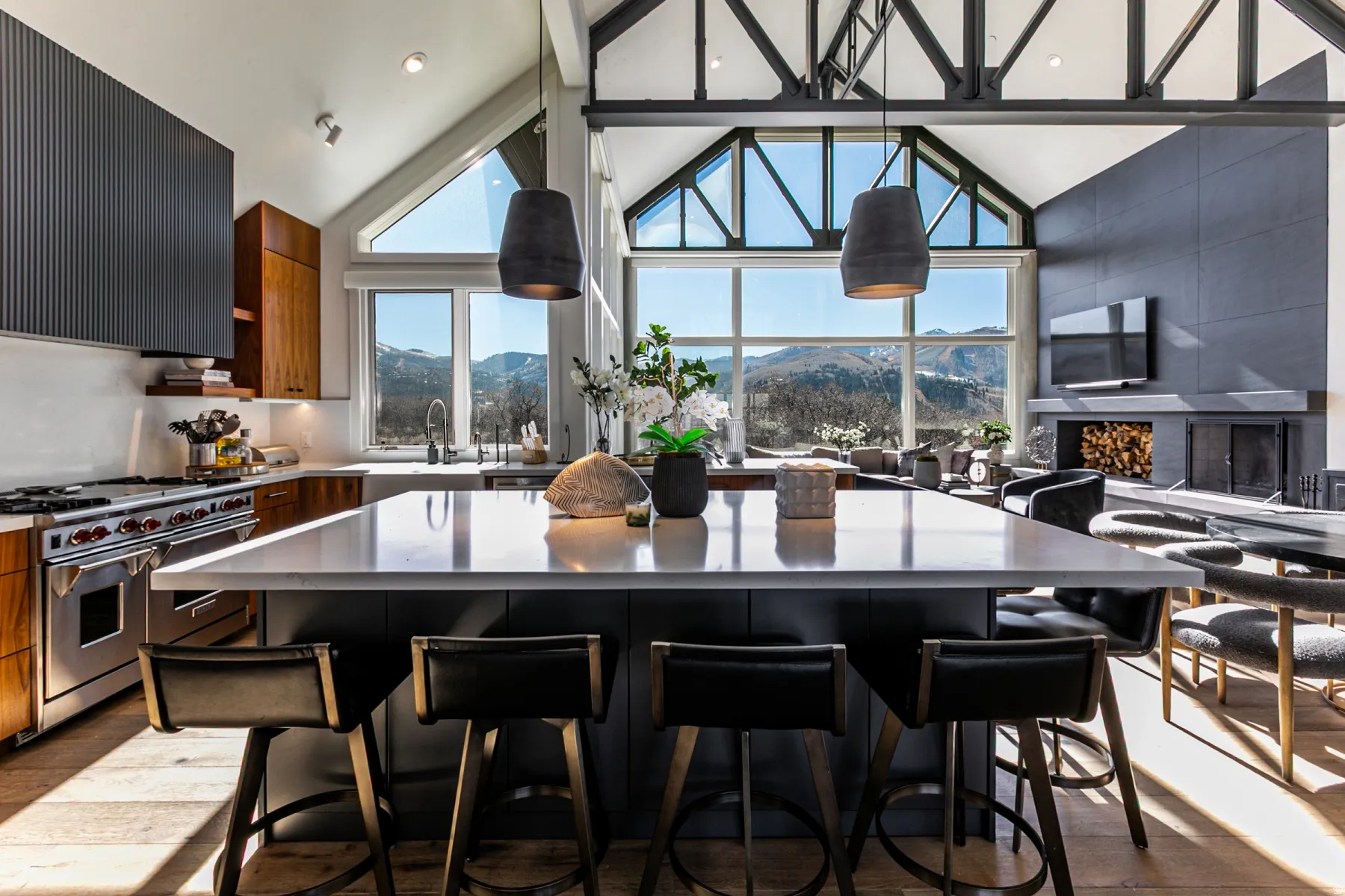 Kitchen with range hood, double oven range, a kitchen breakfast bar, dark wood-type flooring, and dark cabinetry