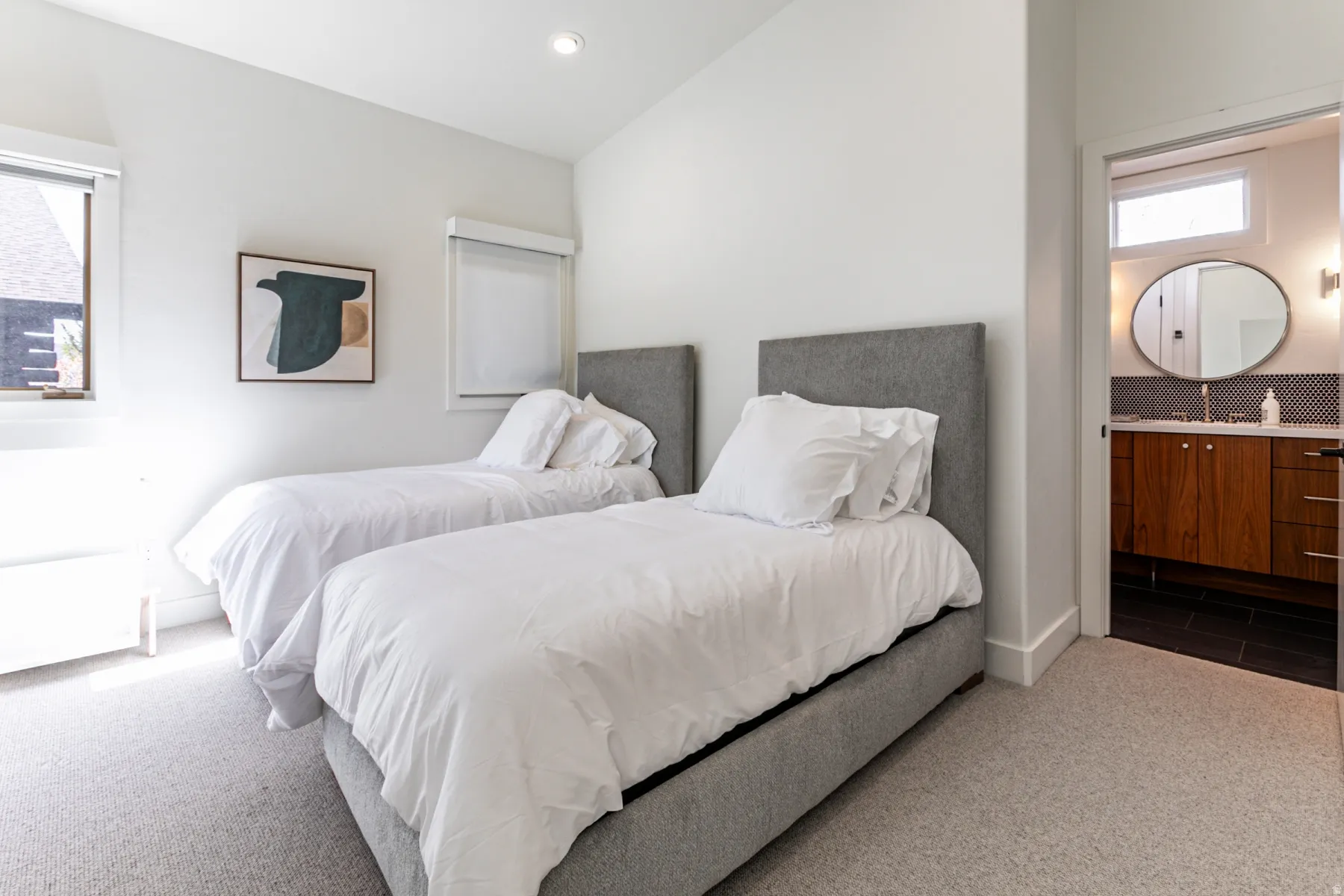 Carpeted bedroom featuring ensuite bathroom, recessed lighting, and lofted ceiling