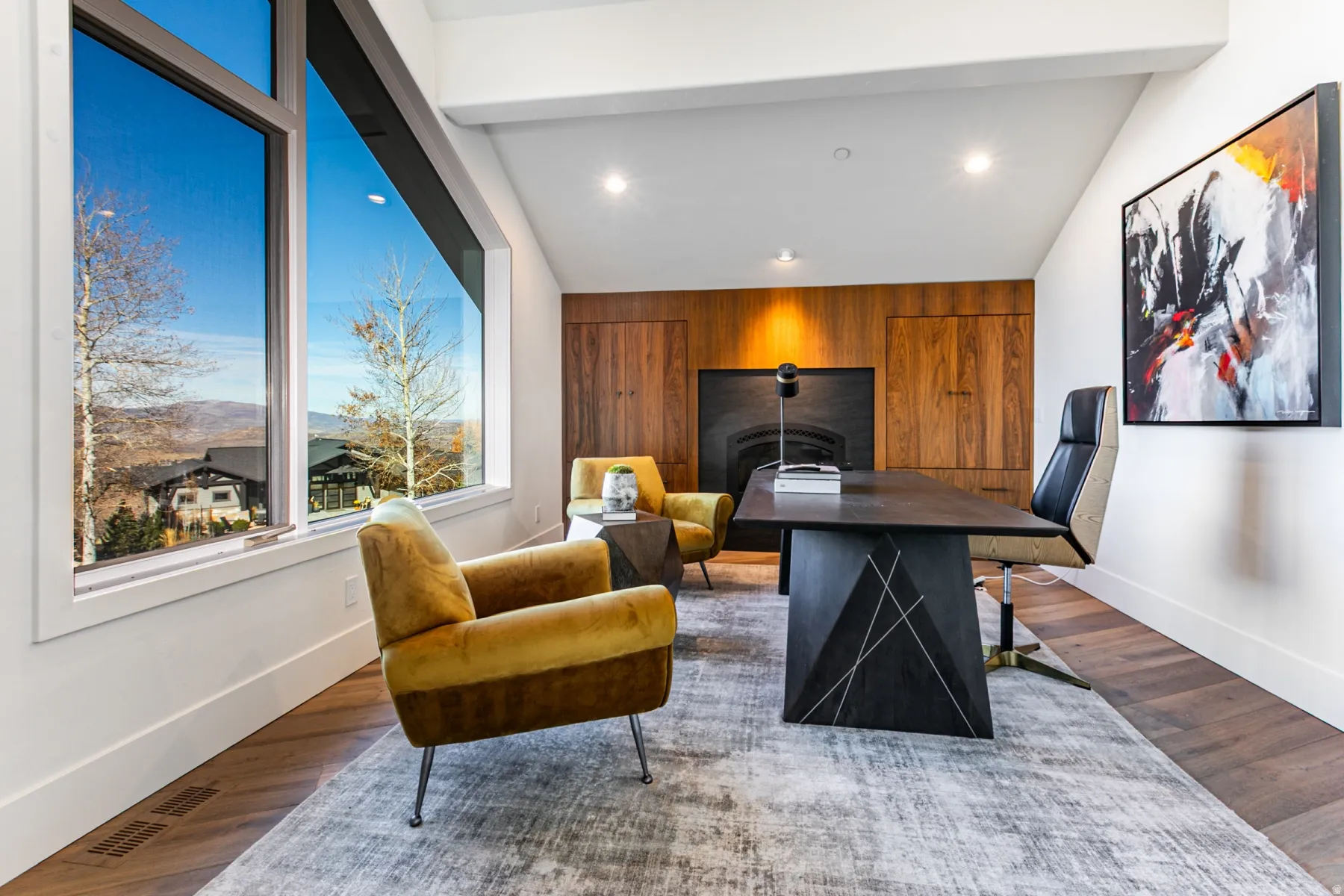 Office space featuring dark wood-type flooring, wood walls, lofted ceiling, a mountain view, and recessed lighting