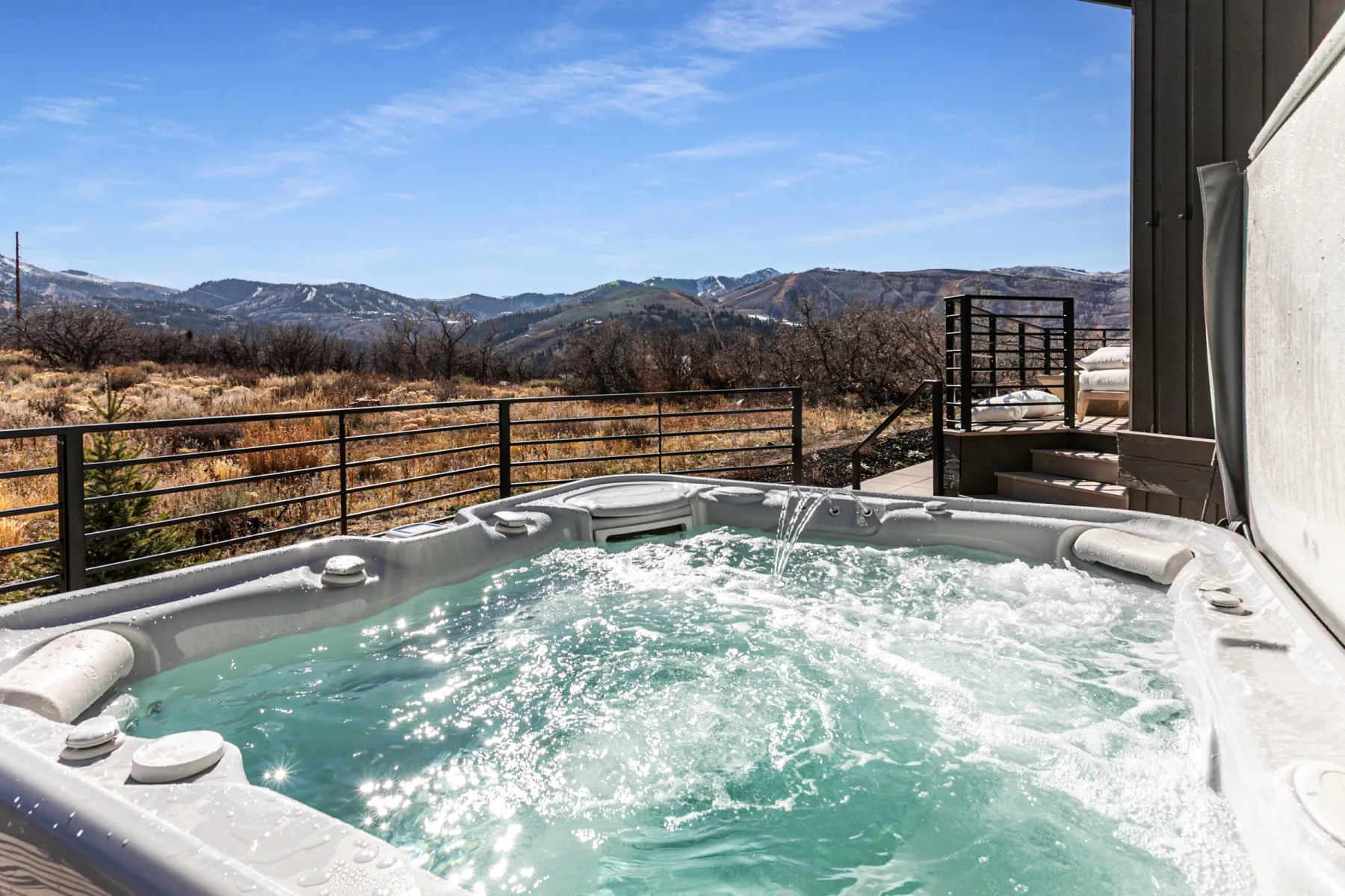 View of pool with a hot tub and a mountain view