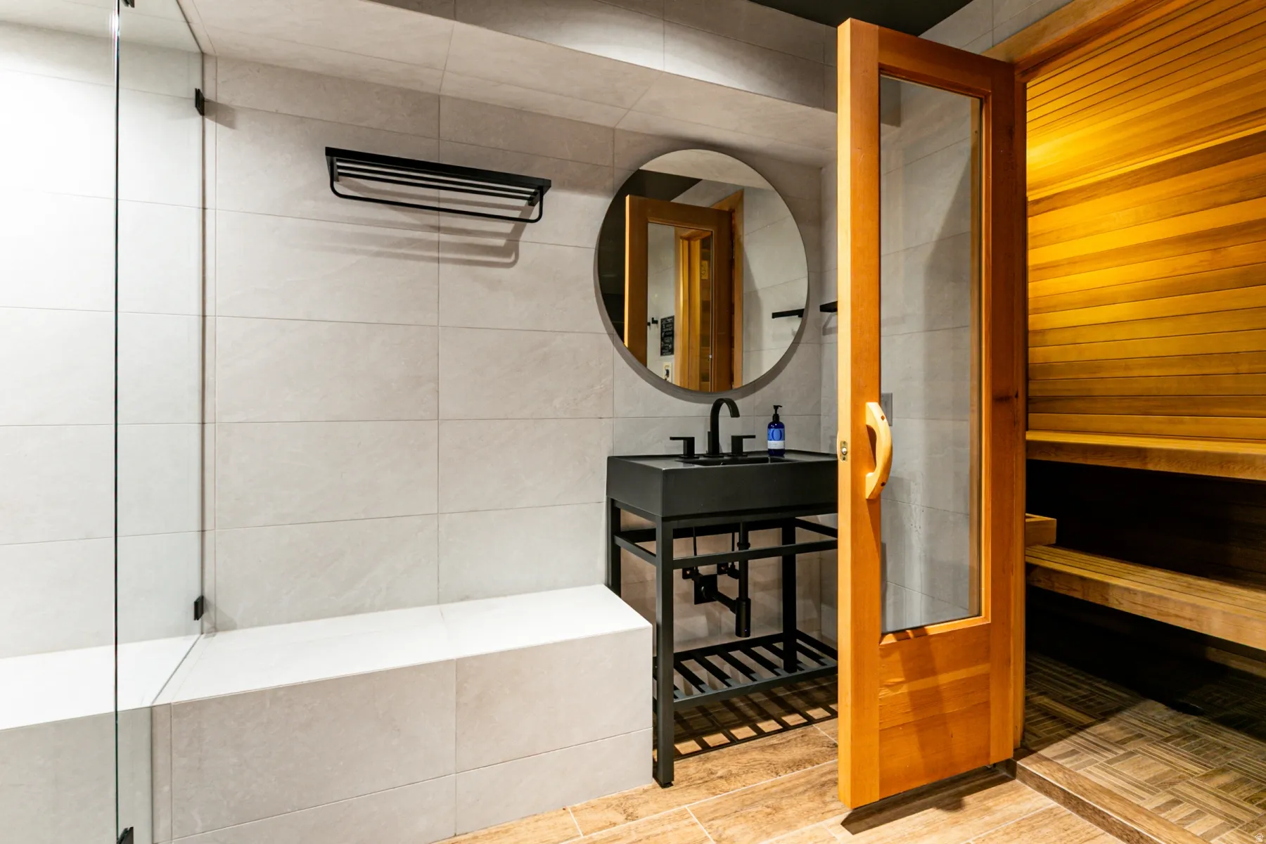 Bathroom with a sauna, tile walls, and wood finished floors
