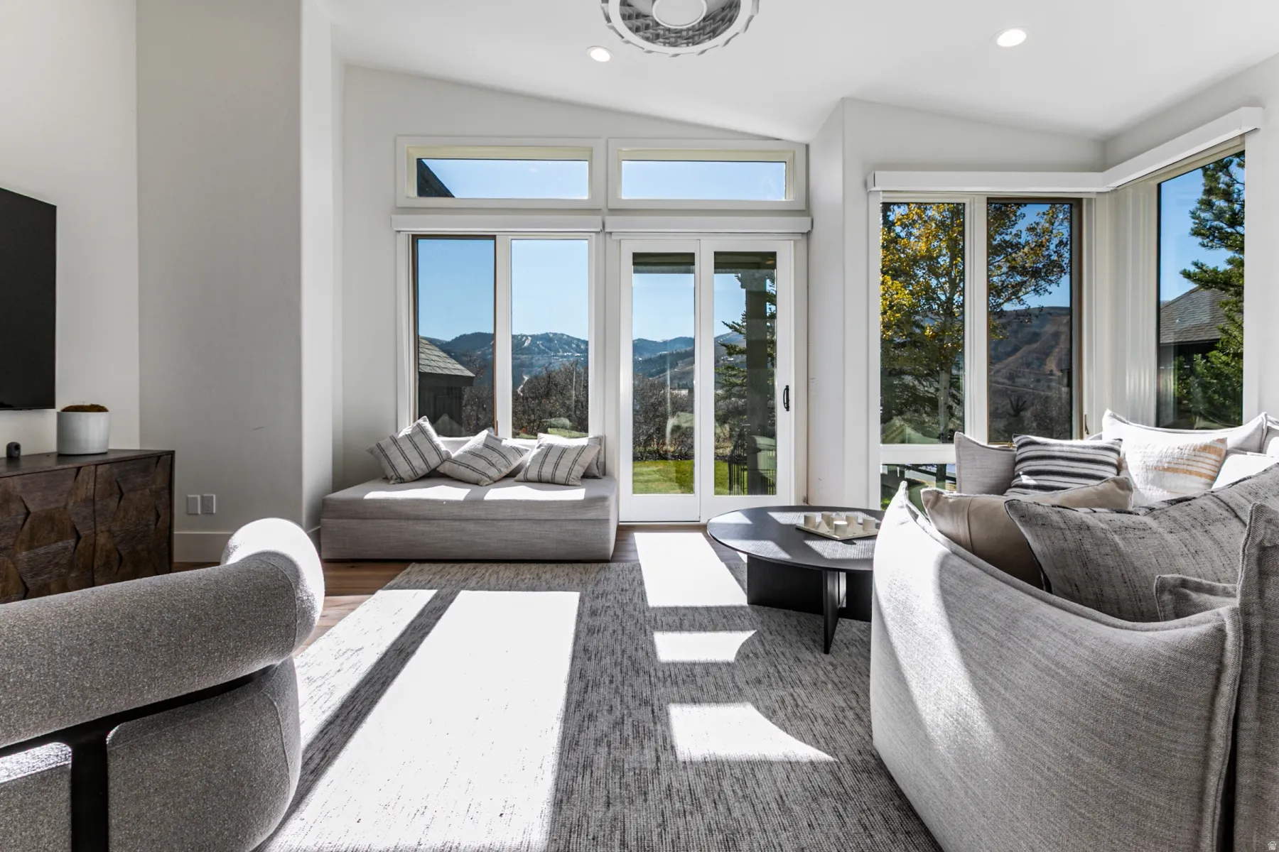 Living room with a mountain view, recessed lighting, lofted ceiling, and wood finished floors